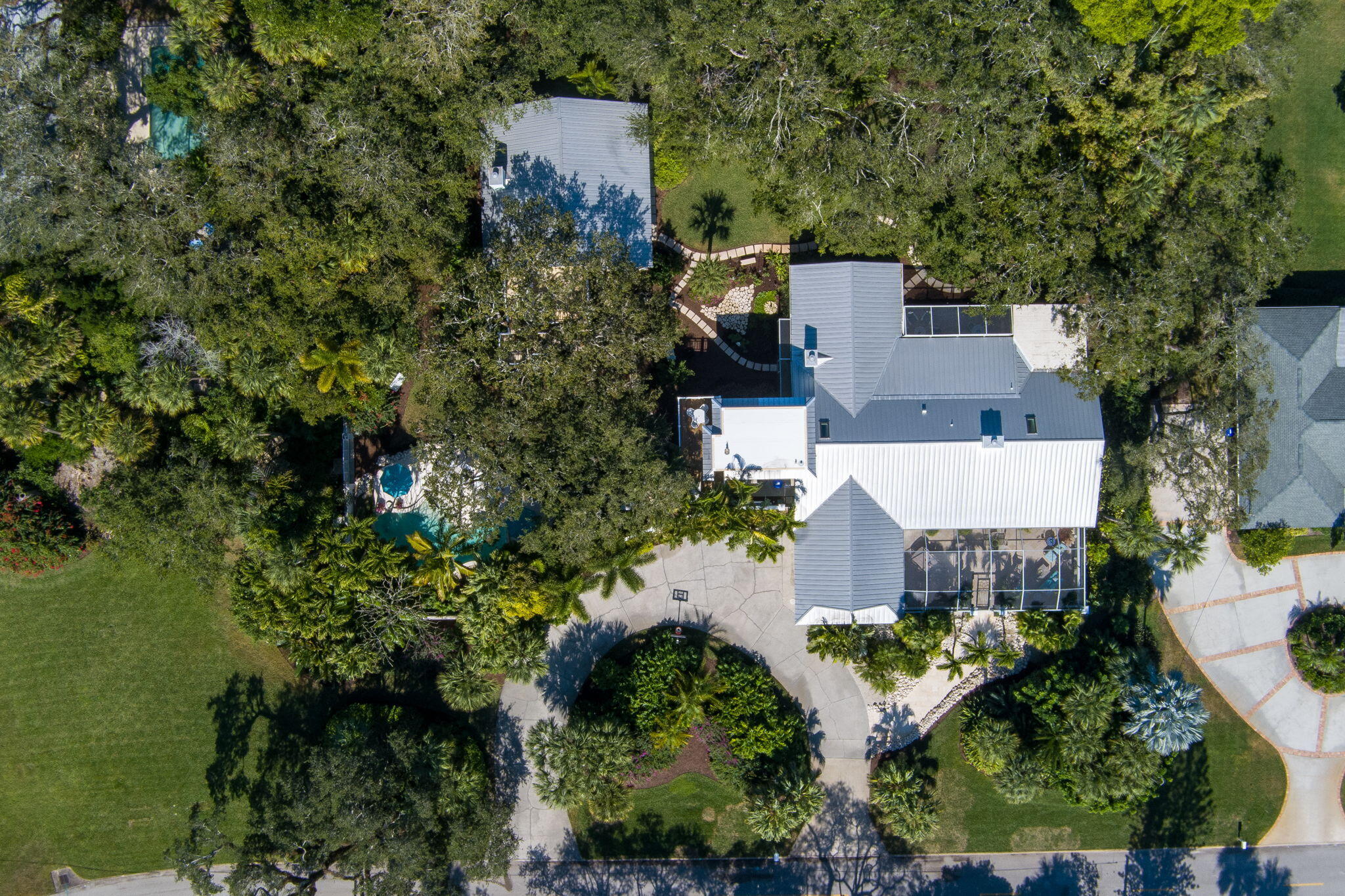 Skinny dip in total privacy in this 1 acre+ central beach estate in pristine condition. Ideal entertaining home perfectly designed for island living - every room leads to a screened patio. Enjoy your morning coffee in a botanical garden setting or an evening glass of wine with gorgeous sunsets above your lagoon shaped pool. Easy walk to dine, shop, theater, museum, tennis, river & ocean.