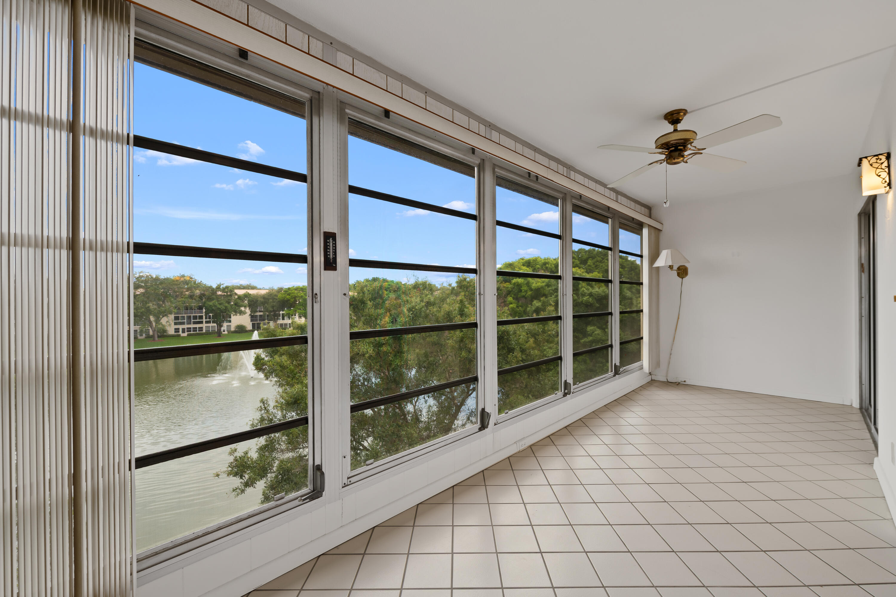 Enjoy serene lake views from this top-floor 2-bedroom, 2-bathroom condo in the beautiful, man-gated community of Wynmoor. This well-maintained unit features a balcony with a jalousie glass enclosure overlooking the water, tile flooring throughout, a hurricane impact front door and windows, A/C replaced in 2021, and a new roof in 2023. All assessments have been paid, offering added value and peace of mind. Per the association, at least one occupant must be 55+, and a minimum 650 credit score is required. Wynmoor Country Club offers an exceptional resort-style lifestyle with a heated pool, 18-hole golf course, water aerobics classes, resistance walking pool, tennis and pickleball courts, bocce, movies, live shows with dancing, over 90 clubs to meet new people, bus service and so much more!