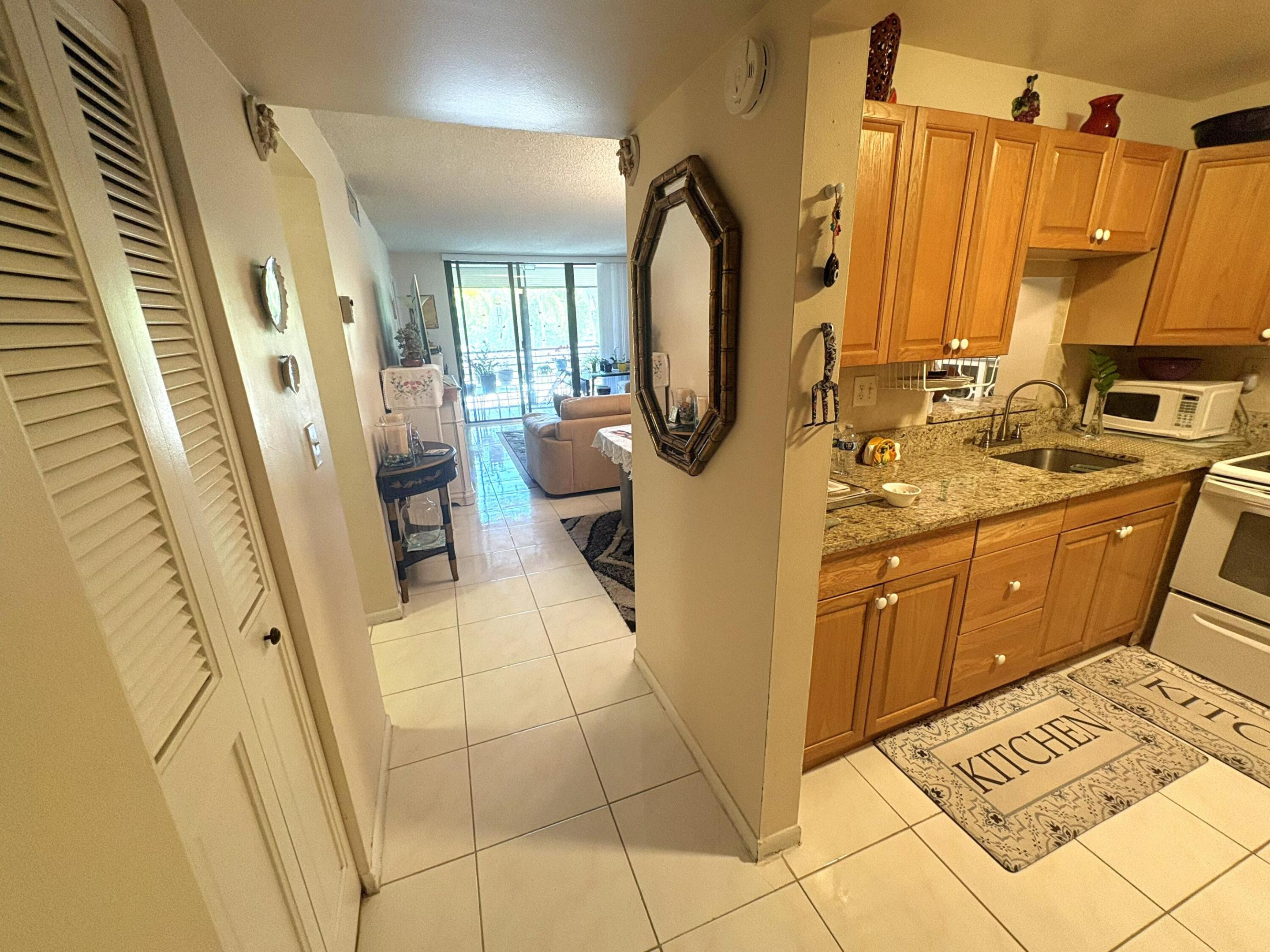 Enjoy effortless South Florida living in this charming Tamarac condo with picturesque pool and golf course views. Designed for both comfort and functionality, the home features an inviting eat-in kitchen complete with granite countertops and warm wood cabinets. Tile flooring throughout creates a seamless flow and low-maintenance lifestyle. Impact windows and doors enhance security, energy efficiency, and storm protection, allowing you to enjoy peace of mind year-round. Wake up to serene vistas and spend your days embracing the relaxed atmosphere this community offers. A newer roof and updated elevator further contribute to the property's appeal and long-term value. This move-in-ready residence presents an excellent opportunity to enjoy a carefree lifestyle in a desirable location close to