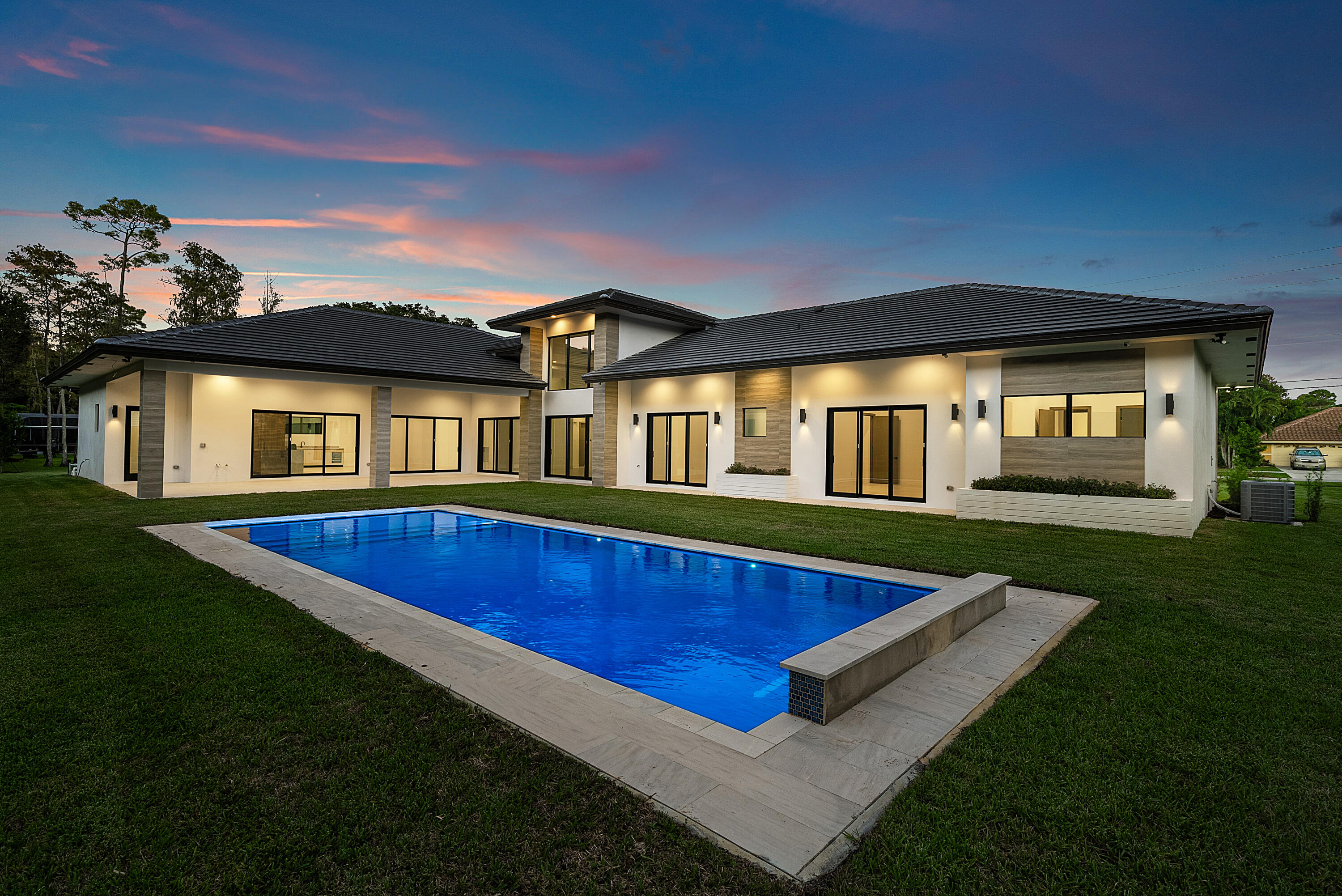 Brand New Construction! This never lived in 5Br / 6.5Bth single-story home breaths a breath of fresh air into Wellington architecture! This 4,823 sq. ft. home is perfectly situated on over 1-acre. The center-island kitchen opens to the family room and showcases Dacor appliances, gas cooktop, custom-crafted cabinetry and an oversized walk-in pantry.  The primary suite offers views to the pool, a spa-like bathroom with a wet room and enormous dressing room for the fashionista. Other features include: home office/den, impact windows & doors, 2 tankless water heaters, 3 A/C units, 3-car garage and circular driveway with an elegant porte-cochère front entry. This wonderful home was designed for the active family who loves to entertain. A prime location within walking distance to great schools.