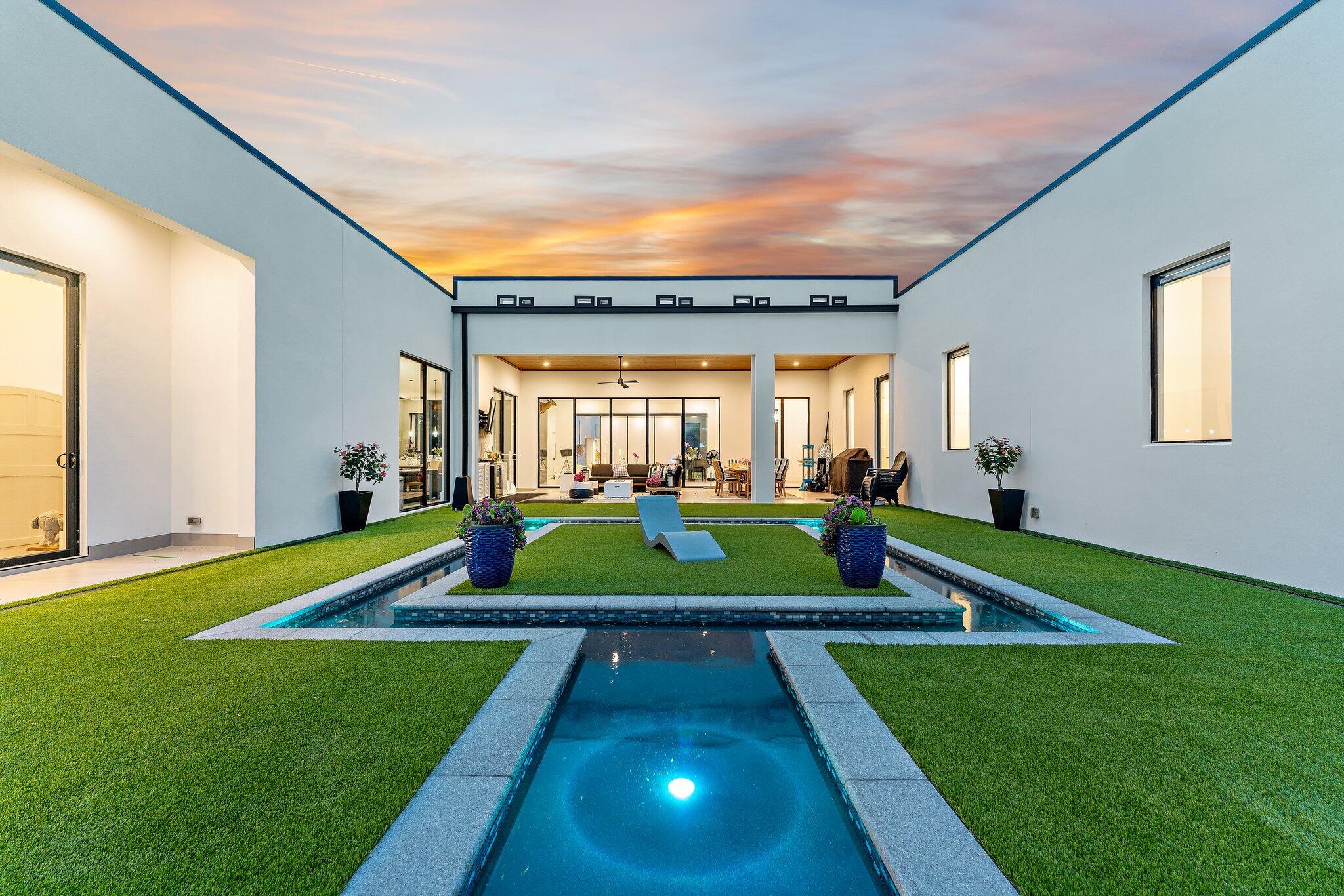 Completed in 2022, this extraordinary contemporary waterfront estate is set on more than 4 private acres along the Intracoastal Waterway. Offering over 100 feet of direct Intracoastal frontage, this exceptional property is ideally suited for boating enthusiasts, car collectors, and those seeking the ultimate in luxury and privacy. A private dock provides direct access to the Intracoastal and is accessed by a scenic 4-foot-wide walkway that meanders through protected lowland mangroves, creating a truly unique approach to the waterfront. The dock features a 4-foot by 56-foot over-water section leading to an 8-foot by 20-foot L-shaped terminal platform, providing ample space for docking, fishing, or simply enjoying the waterfront setting.  Water service is already in place, and electricity can be easily added to accommodate future boating needs.  Thoughtfully designed with sleek architectural lines, soaring 13-foot ceilings, and dramatic floor-to-ceiling glass, the home captures breathtaking views of the resort-style pool, lush grounds, and waterfront beyond. The single-level floor plan offers three spacious bedrooms in the main residence, along with a media/theater room and private office/exercise space, while a detached guest house provides a private suite complete with its own kitchen and full bath.  Car enthusiasts will appreciate the eight-car garage with ample room for vehicle lifts, creating the perfect showcase for an automotive collection. Every bedroom features a luxurious ensuite bath, and the expansive indoor and outdoor living areas are designed for both grand-scale entertaining and comfortable everyday living.  The state-of-the-art chef's kitchen is a true centerpiece, featuring dual oversized islands, gas cooking, double wall ovens, integrated push-open refrigerator and freezer panels, a stunning wine wall, a butler's pantry, and an oversized walk-in pantry. Throughout the home, exceptional craftsmanship and attention to detail are evident in the custom wood and decorative ceilings, designer fireplace, elegant finishes, and seamless indoor-outdoor flow.  The luxurious owner's retreat offers a private sanctuary with rich wood flooring, a fireplace, spa-inspired marble bath with dual vanities and water closets, and an impressive boutique-style walk-in closet. An expansive covered loggia overlooks the spectacular pool and meticulously landscaped grounds, creating a true resort-like setting.  Combining cutting-edge design, world-class amenities, exceptional privacy, direct Intracoastal access, and a private dock nestled among the mangroves, this one-of-a-kind estate presents a rare opportunity to own one of South Florida's most remarkable waterfront properties.