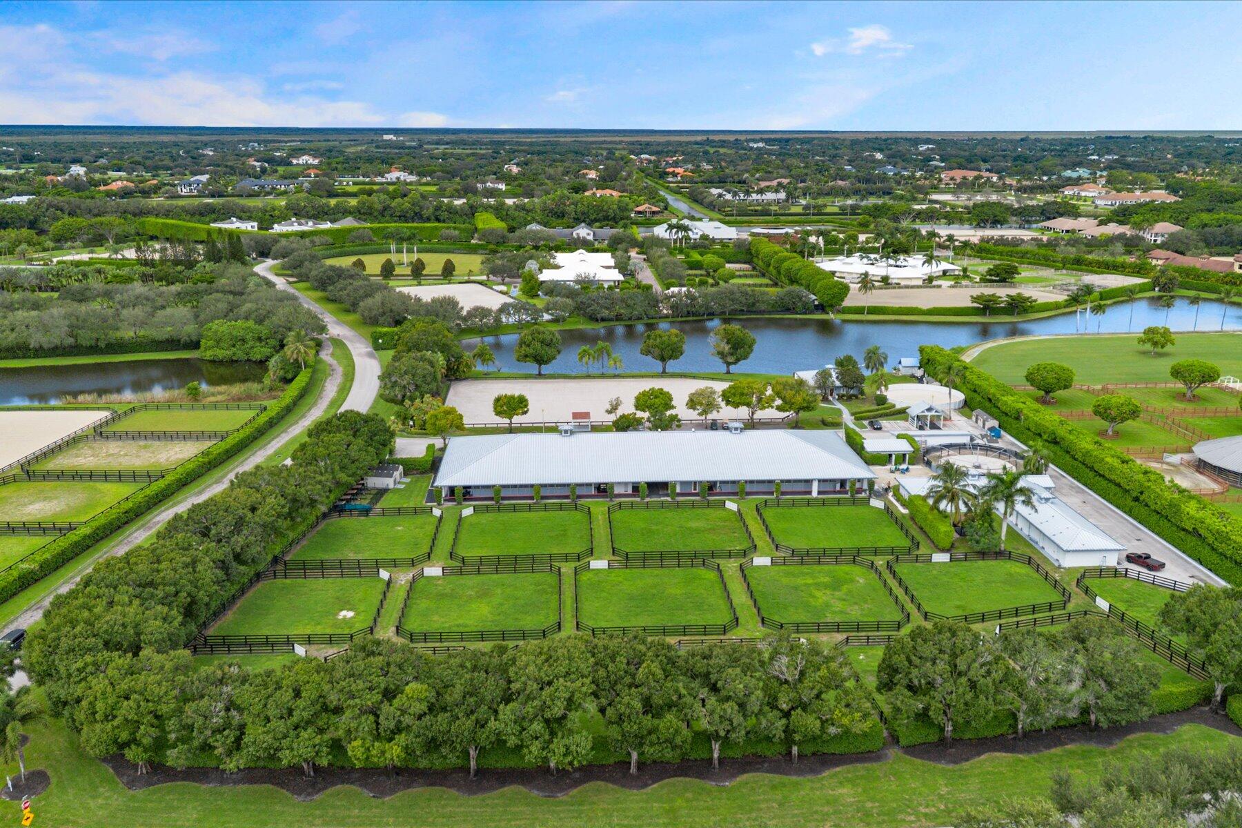 Exceptional 6-acre equestrian estate in Grand Prix Village, adjacent to Wellington International and the new Wellington International South showgrounds. Designed for both horse and rider, the property features 16 lush grass paddocks, towering mature trees, and a perimeter of established hedges that create a private, park-like setting. The 140' x 230' arena offers premium fiber footing and new drainage, complemented by a 6-horse walker and lunging pen. Residential accommodations include a 3-bedroom, 2-bath manager's cottage and 8 studio apartments. With dual entrances for owners/riders and staff, ample parking, and exceptional proximity to world-class competition venues, this property represents a rare opportunity in Wellington's premier equestrian community. Barn Features:  Fifty-six 10' x 10' stalls, each equipped with fans, rubber mats, and water.  Eight barn blocks, each containing seven stalls.  Each block has a dedicated wash rack, tack room, and feed room.  Two laundry rooms, each featuring two washers and two dryers.  Durable metal roofing throughout the property.  Thoughtfully designed circulation patterns to ensure efficient and safe movement for horses, riders, owners, and staff.  Ample parking for vehicles, trailers, and farm operations.