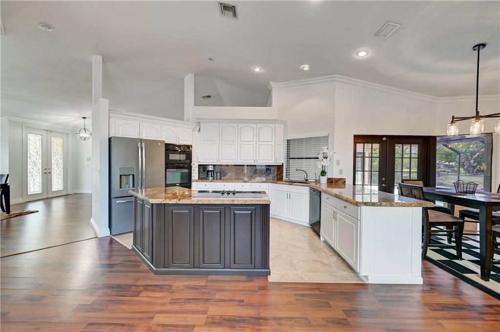 This Beautiful 5/2.5 home in Pine Ridge has undergone some impressive updates, and is a rarely available model with a 3-car garage. This updated chef's kitchen with SS appliances, granite counter tops, and as well as the real wood cabinets are likely to be features that will be highly attractive to potential buyers.  The new paint, sprinklers, light fixtures, and drapery also bring appeal. Additionally, the lg master bedroom with a walk-in closet is a woman's dream. Don't forget the 2018 AC and 2019 Hot water heater. This property has a lot to offer and a dream home to the buyer looking for space, waterfront and a pool. These updates make this home a joy to show. Don't walk - Run before its gone