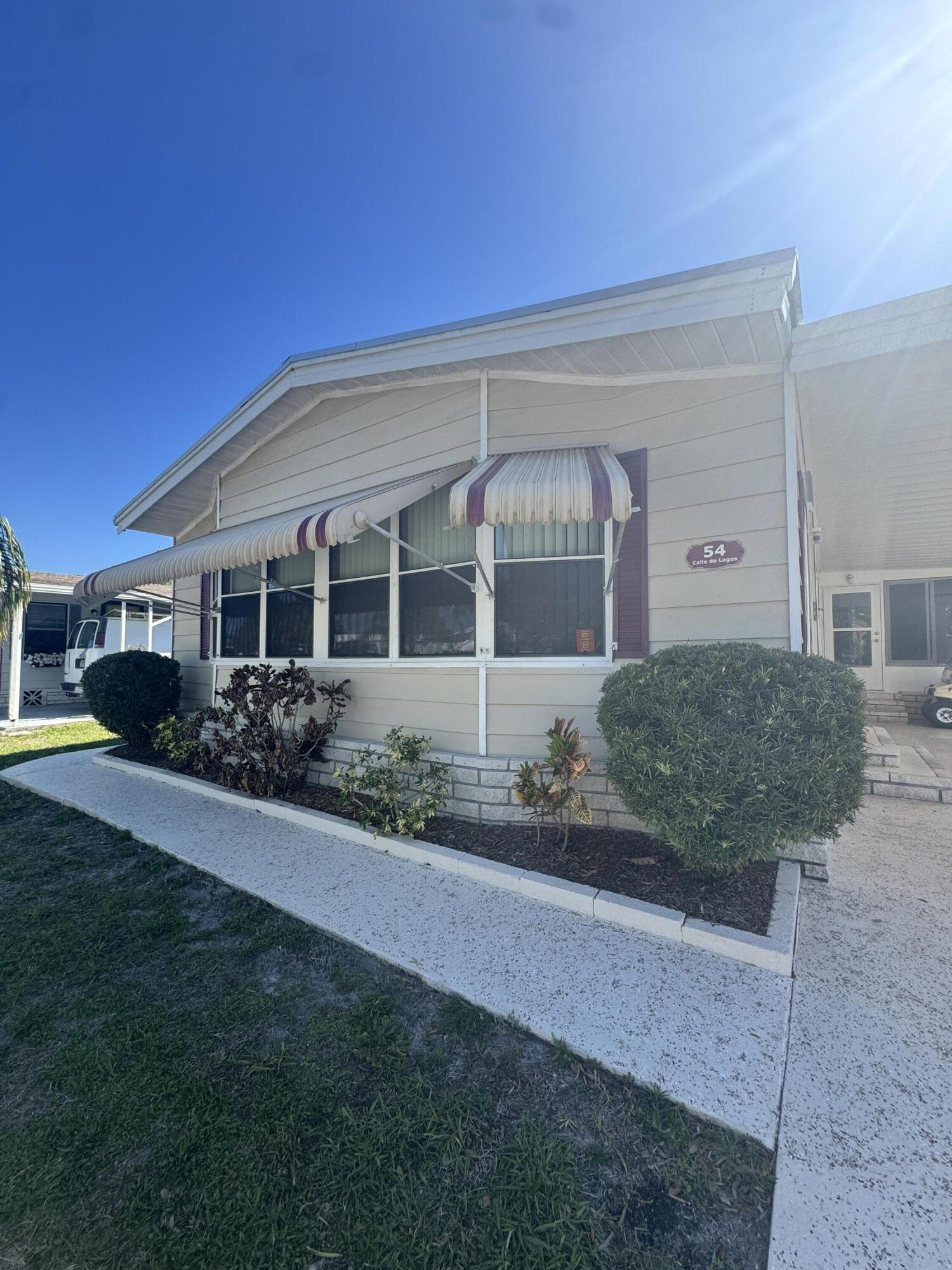 Well-maintained 2-bedroom 2-bath home in desirable 55+ Spanish Lakes community. This home backs up to a private wooded area. The home has many major improvements. New metal roof 2024, A/C replaced in 2023, Water heater 2023, Vapor barrier 2023, Patio windows replaced 2025. Driveway painted in 2025. This home has built-ins for added storage. Open kitchen with an island. Home is being sold partially furnished. The home has brick skirting and pavers around the home. Nicely landscaped. Close to the entrance of the park. Partial water view from the front of the home. . Lawn care and trash removal are included in the lot rent. The community features two pools, tennis, pickleball, bocce ball, and shuffleboard. Clubhouse and much more.