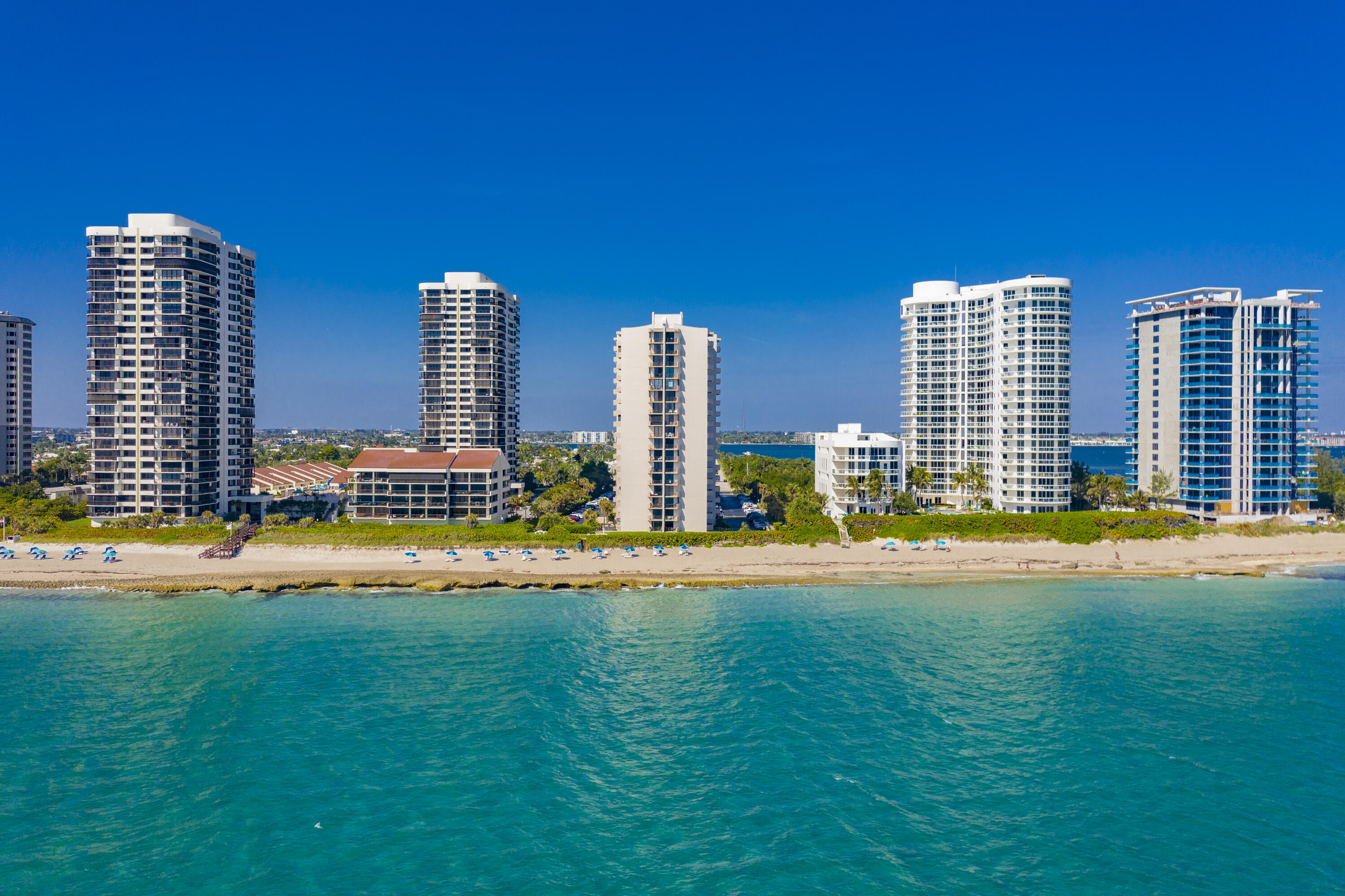Discover coastal living on Singer Island in this inviting 2BR, 2BA corner condo featuring a desirable split floor plan. The residence offers a full laundry room, spacious walk-in closet, and abundant storage throughout. Freshly painted with complete impact sliders. Enjoy sweeping views of the city skyline, the Intracoastal Waterway, and the Atlantic Ocean from this light-filled unit. Updated bathrooms add modern comfort, while resort-style amenities include a pool, fitness center, sauna, and book room, plus the convenience of on-site management. A covered parking space near the building entrance is included, along with ample guest parking. Sidewalks nearby provide easy access to local restaurants, shops, and coastal activities.