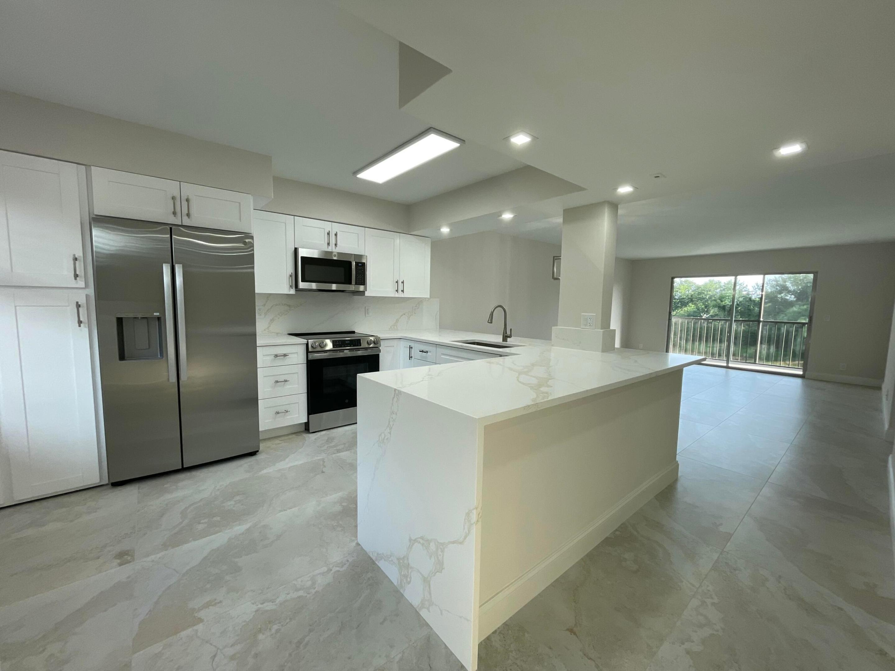 **MUST SEE** Move right into this gorgeous contemporary 2 bed / 2 bath apartment in the sought-after, Guard-Gated, Huntington Lakes 55+ community! This property features sensational, serene water views. Fall in love with the beautifully renovated open-kitchen, with white shaker cabinets, all Quartz countertops, with a sleek waterfall construction, stainless steel appliances, 2 Lazy Susan's for cooking and entertaining. New LG washer/dryer, Stunning Porcelain 24"x48" tiles throughout, and tastefully designed brand new bathrooms.  A/C 2024, water heater 2026, this sub-division enjoys the *Lowest HOA's in the entire community," at only $759.53, which includes cable, outdoor MT, water, trash & sewer. All this with a brand newly transformed modern clubhouse with indoor & outdoor pools,  enormous theater, gorgeous locker rooms, tennis, pickleball, card rooms, Billiards room and activities galore! 10 minutes to the beach and only minutes to the famous, Atlantic Ave with endless shops & restaurants!! Live here and have it all!