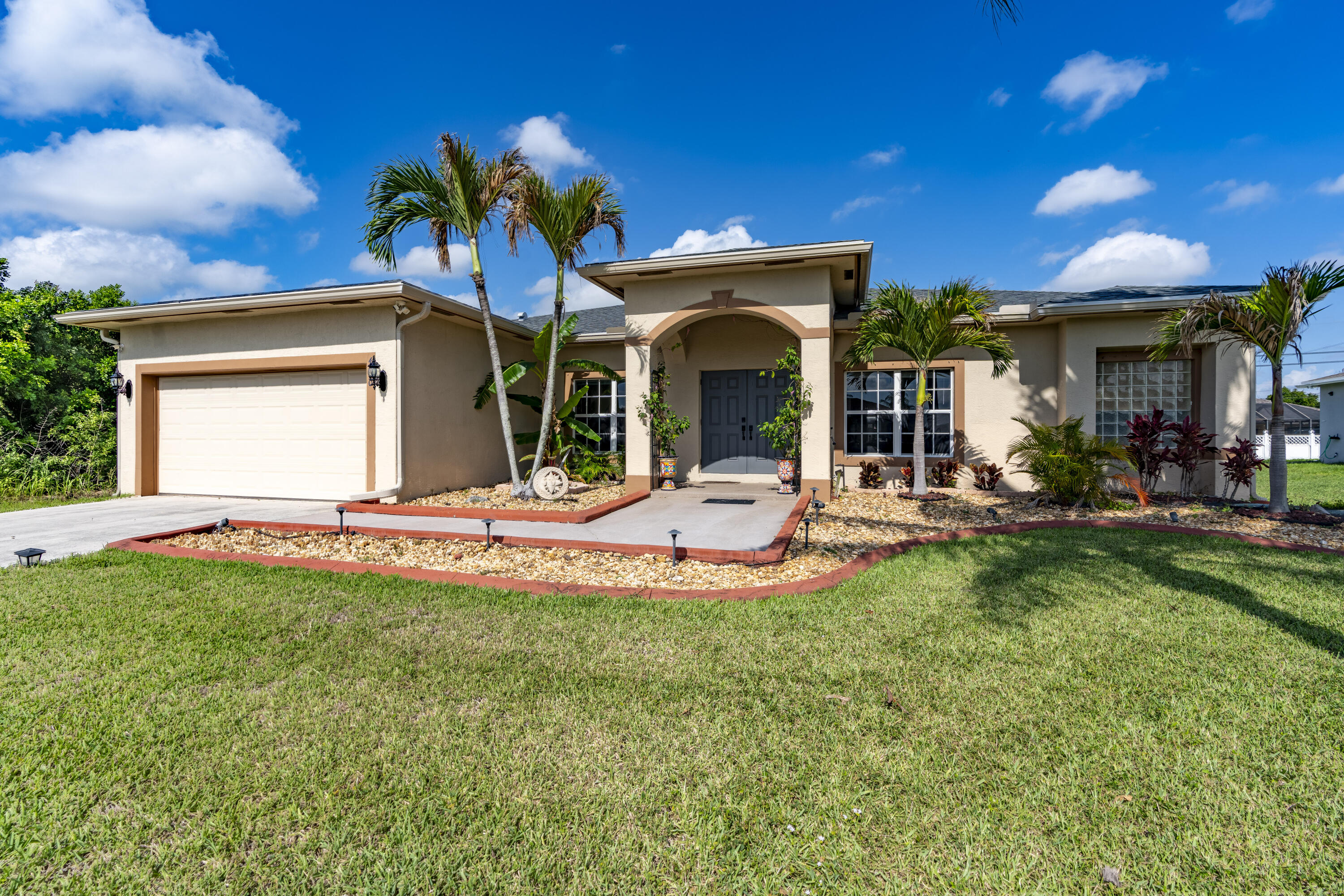Welcome to this beautifully maintained and move-in-ready 4-bedroom, 2-bath CBS home offering 1,910 square feet of comfortable living space in the highly sought-after Becker area of Port St. Lucie. This spacious contemporary home combines thoughtful updates, architectural charm, and exceptional indoor-outdoor living complete with generator connection. Recent improvements provide peace of mind and modern convenience, including a 2021 shingle roof, 2020 air conditioning system, 2021 hot water heater, LG stainless steel kitchen appliances, and  newer washer and dryer. The professionally refreshed landscaping creates outstanding curb appeal. Step inside to discover a bright and airy split-bedroom floor plan filled with natural light. Elegant  tray ceilings in the living room, arched doorways, and multiple sliding glass doors add architectural interest and enhance the open feel of the home. Luxury vinyl flooring flows throughout the main living areas, while all bedrooms feature comfortable carpeting. The spacious kitchen offers both an eat-in breakfast area and easy access to the formal dining room, making it ideal for everyday living and entertaining. Three sets of sliders in the main living areas seamlessly connect the indoors to the expansive outdoor patio, while an additional set of sliders in the primary suite provides direct access to the backyard retreat. The oversized primary suite features a walk-in closet and a luxurious ensuite bath complete with a Roman tub. Outside, enjoy your own private backyard oasis with an extended patio, pergola, and remote-controlled awning—perfect for relaxing or entertaining guests. The pool table is included, making this home truly move-in ready and ready for fun. Situated on a generous 0.23-acre lot with plenty of room for a custom pool, this home also includes storm shutters, public water and sewer, and a 2-car attached garage. Conveniently located near I-95, shopping, dining, and everyday amenities, this exceptional property offers the perfect combination of space, updates, style, and location.