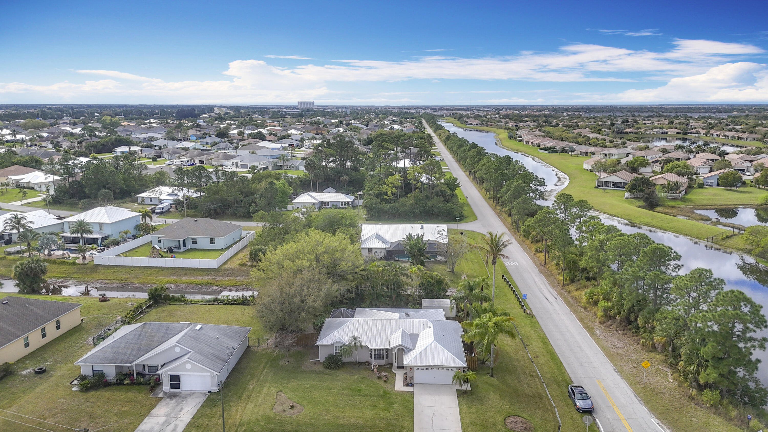 This beautifully updated home in a prime Port St. Lucie location Just 15 miles to Jensen Beach! offers charm, style, and durability. Featuring tile, engineered hardwood, and laminate flooring, it boasts elegant upgrades like 6-inch baseboards, crown molding throughout, and plantation shutters. The kitchen and bathrooms shine with granite countertops, while a spacious, fully fenced backyard includes a large 12' x 16' storage shed for added convenience. An exceptional highlight of this home is the expansive 13' x 36' air-conditioned and heated bonus room adjacent to the kitchen, perfect for a family room, home office, or entertainment space. Situated on a desirable corner lot, this home also comes with a long-lasting metal roof and custom hurricane shutters, providing both security and peace of mind. Don't miss this move-in-ready gemschedule your showing today!
