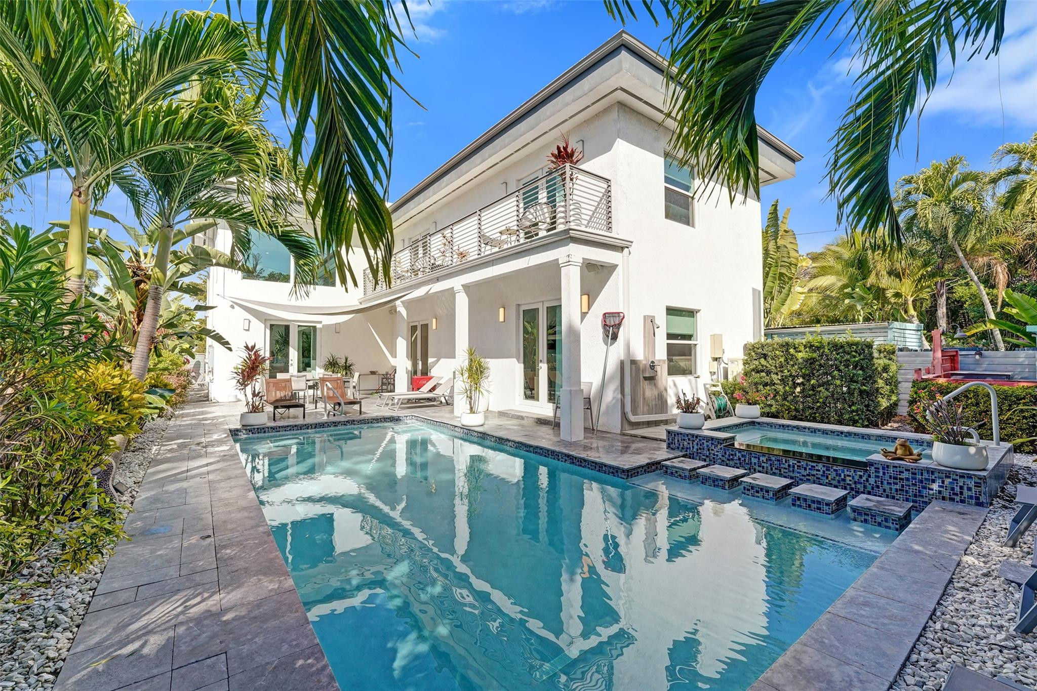 Welcome to Casa Hermes, a stunning modern residence just 2 blocks from vibrant Wilton Drive. This impressive home offers 5 bedrooms, 5 bathrooms, 2,862 sqft under air and 3,185 total sqft. Enter through a dramatic 22-foot ceiling with a striking floating staircase and open, light-filled living spaces. The private backyard feels like a resort with a heated pool, hot tub, outdoor shower, and custom lighting. Enjoy two upstairs terraces for additional outdoor living. Complete with a 2-car garage and located just 10 minutes to the beach and downtown Fort Lauderdale. A very successful income-producing property, ideal as a primary home, vacation retreat, or investment opportunity. THIS IS A MUST SEE!!