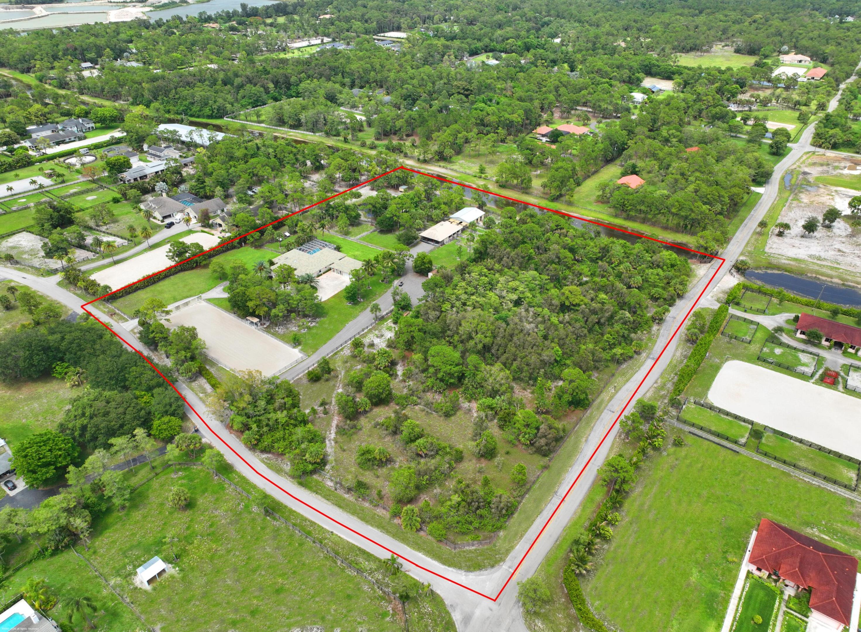 Exceptional 10-acre equestrian estate designed for the serious horseperson. The property features a 3Br/2.5Bth home with an office & flex/game-room which could easily convert to a 4th bedroom suite. The screened patio & heated pool offer extended entertaining space w/ views of the fields and stables. A major selling feature is the separate 1Br/1Bth guest house with an office offering flexible use.  The equestrian amenities include 12 stalls, each with its own run-out paddock, 4 large grass turnout fields, 6 wash/grooming racks, and a dedicated hay shed. Train at home in the regulation-size dressage arena complete with mirrors or build a jumping arena if that's your passion. Additional highlights include: Thermador appliances, impact windows, updated primary bathroom, & 4-car garage. This listing is comprised of two 5-acre parcels and located on Buck Ridge Trail offering easy access into White Fences for schooling shows.  All improvements are on one parcel.  The corner lot is unimproved offering the new owner the ability to customize the layout & improvements; a great spot to build your covered arena, paddocks, exercise track or more stabling.  The game room has French doors which open to the pool and features a wet-bar and half-bath offering flexible use and conversion options. The riding arena has GGT footing, popup sprinklers, mirrored wall, and covered viewing platform with electric, fans and lighting. There are two gated entrances, one to the residence and one to the stabling area which offers ample parking for boarders, trucks & trailers. Replacements: House hot water heater May 2023; Primary Bedroom AC January 2025; AC#2 September 2022;  and guest house AC 2016.  The is a separate electric meter at the stables. The portable generator will convey. Washer & dryer are excluded.