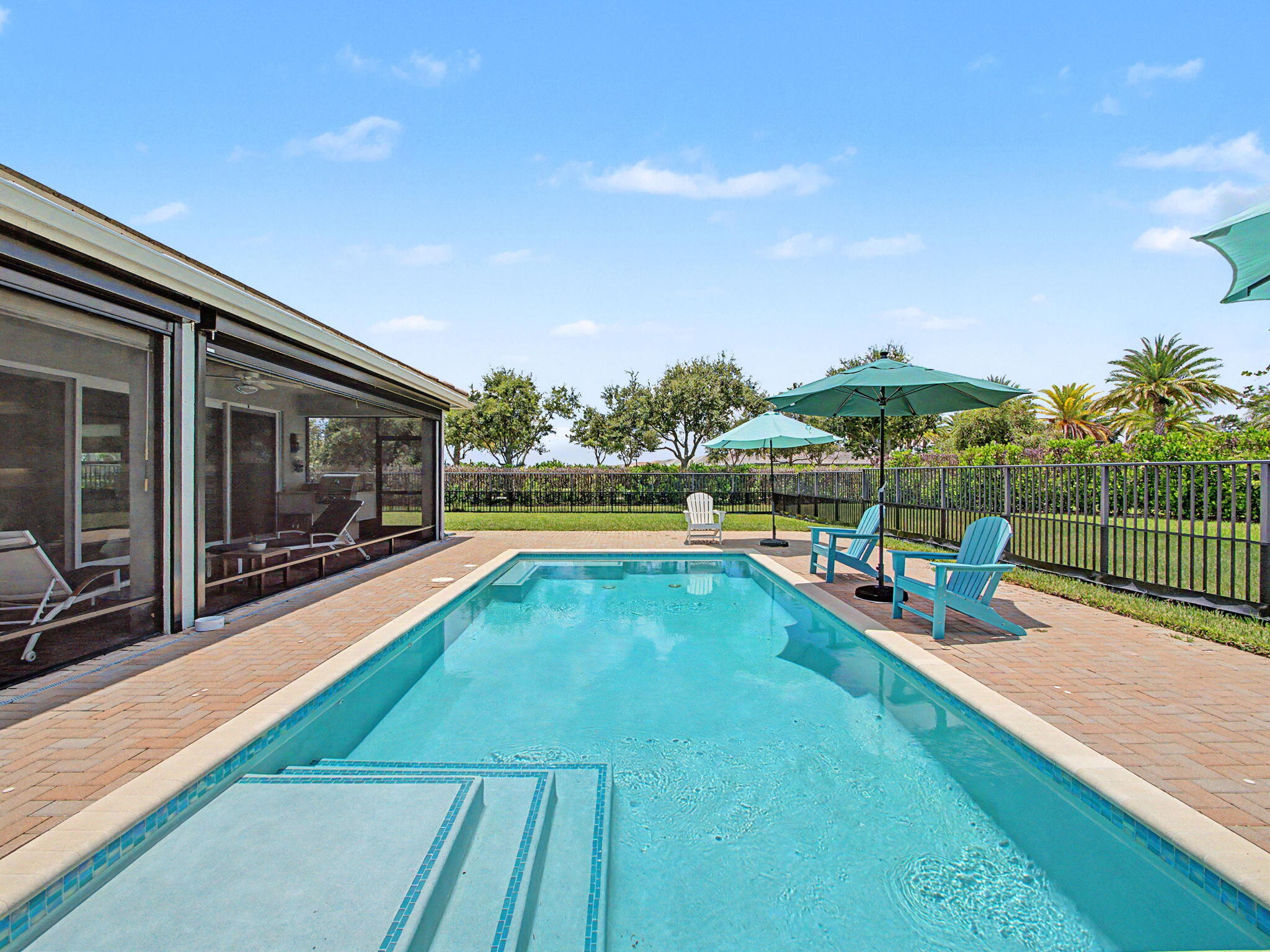 Welcome to this extensively upgraded 2-bedroom plus den, 2 ½ bathroom Atlantica model pool home in the 55+ Valencia Cay at Riverland. Highlights include a saltwater heated pool, extended covered lanai, outdoor kitchen with natural gas, golf cart garage addition, widened driveway & walkway, whole-house water filtration, tankless water heater, variable-speed HVAC system, electric vehicle charger, and portable generator connection. Western rear exposure provides beautiful sunset views across the greenway, with  the Paseo conveniently located beside the home. Inside, the kitchen features white quartz countertops, a matching full-height backsplash, under- and above-cabinet lighting, a newer Samsung refrigerator, matching microwave, two ice makers, and under-sink filtered drinking water. The den includes pocket doors, recessed lighting, blinds, and a floor electrical outlet. An upgraded glass front door panel, screened entry, designer light fixtures, ceiling fans & easily removable accent wallpaper add style throughout the home.  The primary suite offers upgraded bathroom with quartz countertops, rectangular undermount sinks, upgraded faucets, a frameless shower enclosure, ceiling-height tile, a comfort-height toilet, grab bar, pocket door, and frosted privacy window. The 1/2 bath has been converted into a spa sanctuary with a deep luxurious, soaking tub replacing the toilet.  The guest bathroom features a deep soaking tub, upgraded faucet, comfort-height toilet, grab bar, and frosted window.  The extended lanai is protected with hurricane screens and  solar shades for convenience and relaxation.  The extended paver deck, outdoor shower, summer kitchen,  doggie door, and toad fence complete the outdoor space. Additional features include an upgraded GE washer and dryer, laundry sink with cabinet, added shelving, Uba Tuba granite countertop, polyaspartic garage floor, and pull-down attic stairs with storage.