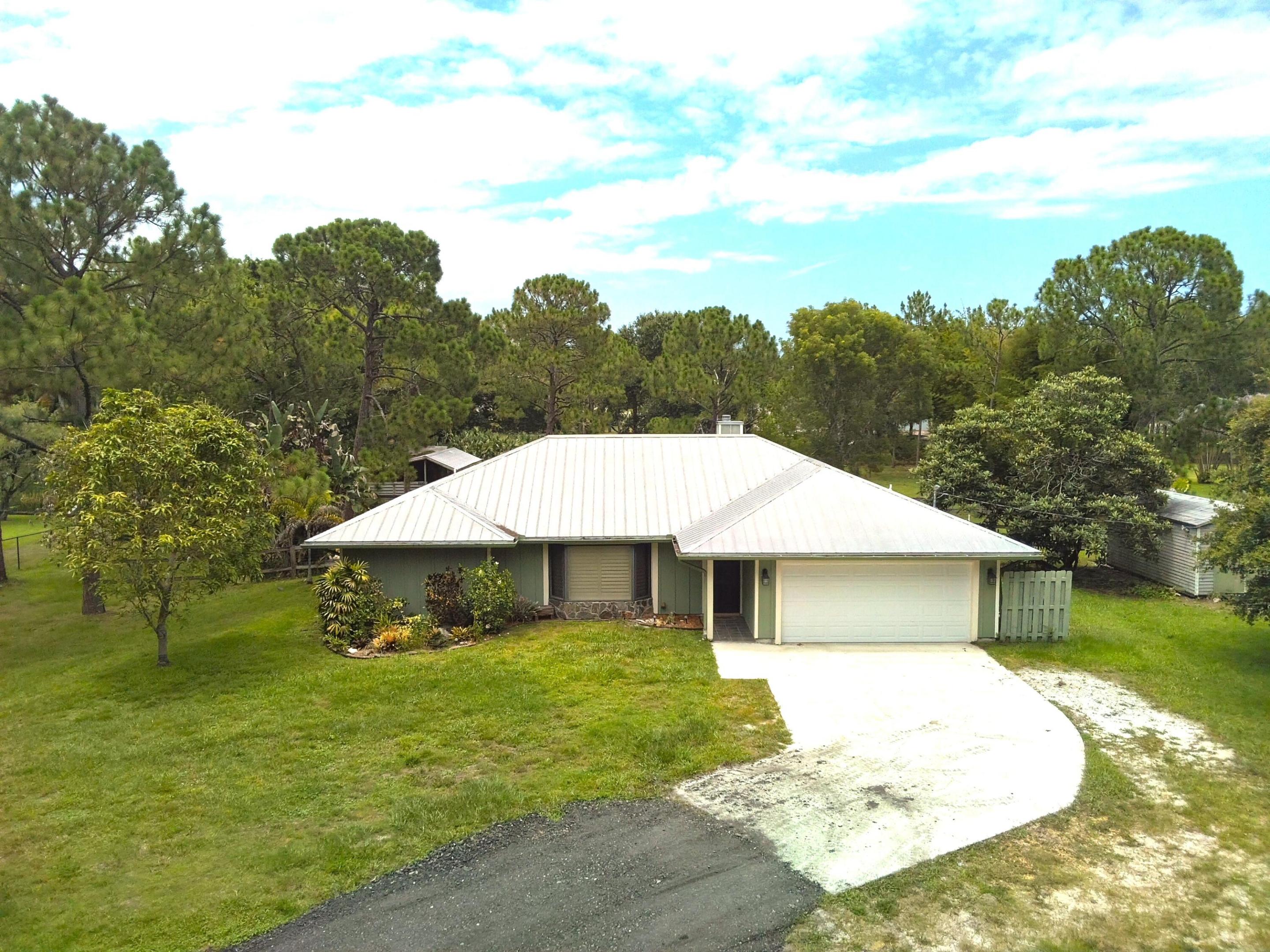Space, freedom, and room to grow in Jupiter Farms. This 1.25 acre property offers a rare blend of privacy, flexibility, and laid-back Florida living. Ideal for families, hobbyists, or equestrian use. Inside, the home features a bright, comfortable layout filled with natural light and ready for your personal touch. Step outside to wide open space where kids and pets can roam freely, weekend gatherings come easy, and there's plenty of room to add a pool, garden, or custom outdoor retreat. Equestrian-friendly with a barn currently set up for one horse, plus no HOA. Bring your boats, RVs, trailers, and more. Tucked away on a paved road, just a short drive to top-rated schools, shopping, dining, and Jupiter's beautiful beaches, this property offers the best of space, lifestyle, and convenience.