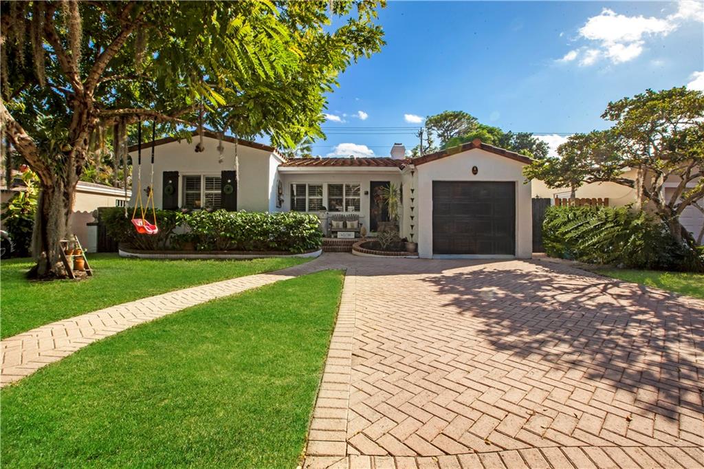 Welcome Home to Rio Vista, one of E. Fort Lauderdale's most coveted subdivisions. Warm, cozy, tranquil, updated are just a few of the adjectives to describe this quintessential residence. Mature landscaping with hanging Spanish moss sets the entry to a covered porch & original doorway. The living and dining room share warm wood flooring and a classic fireplace. The updated kitchen overlooks the breakfast area and opens onto a spacious family room with doorways that blend indoor and outdoor living spaces. The primary suite offers two walk-in closets and a bathroom complete with dual sinks, a separate shower & whirlpool spa. The 2nd bedroom is spacious in size & the 3rd bedroom with bathroom is currently used as a home office. A covered loggia overlooks the pool & garden. Sq ft from IMAPP
