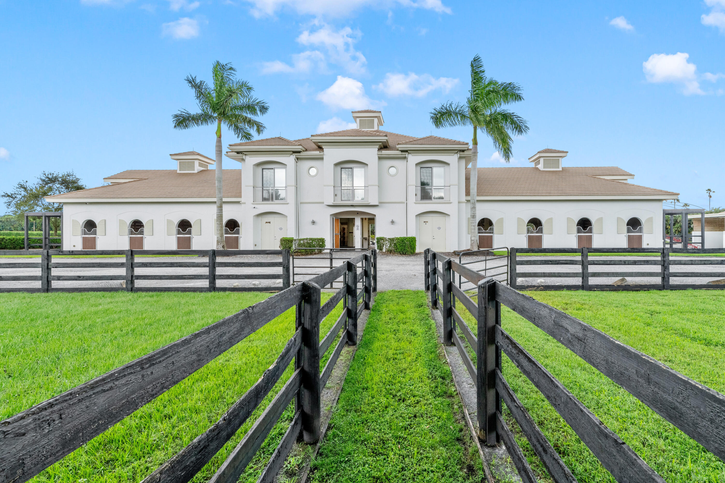 Sprawling 4.5-acre farm with 20 spacious 12x12 stalls, 12 paddocks, an expansive 180x220 arena, and a dedicated jumping field. This equestrian paradise also features accommodations, including a one-bedroom apartment, two-bedroom apartment, and one efficiency unit. The main house boasts 4 bedrooms, 2 1/2 bathrooms, a private pool, city water, and a backup generator. All this in a prime location, just minutes away from the horse show grounds