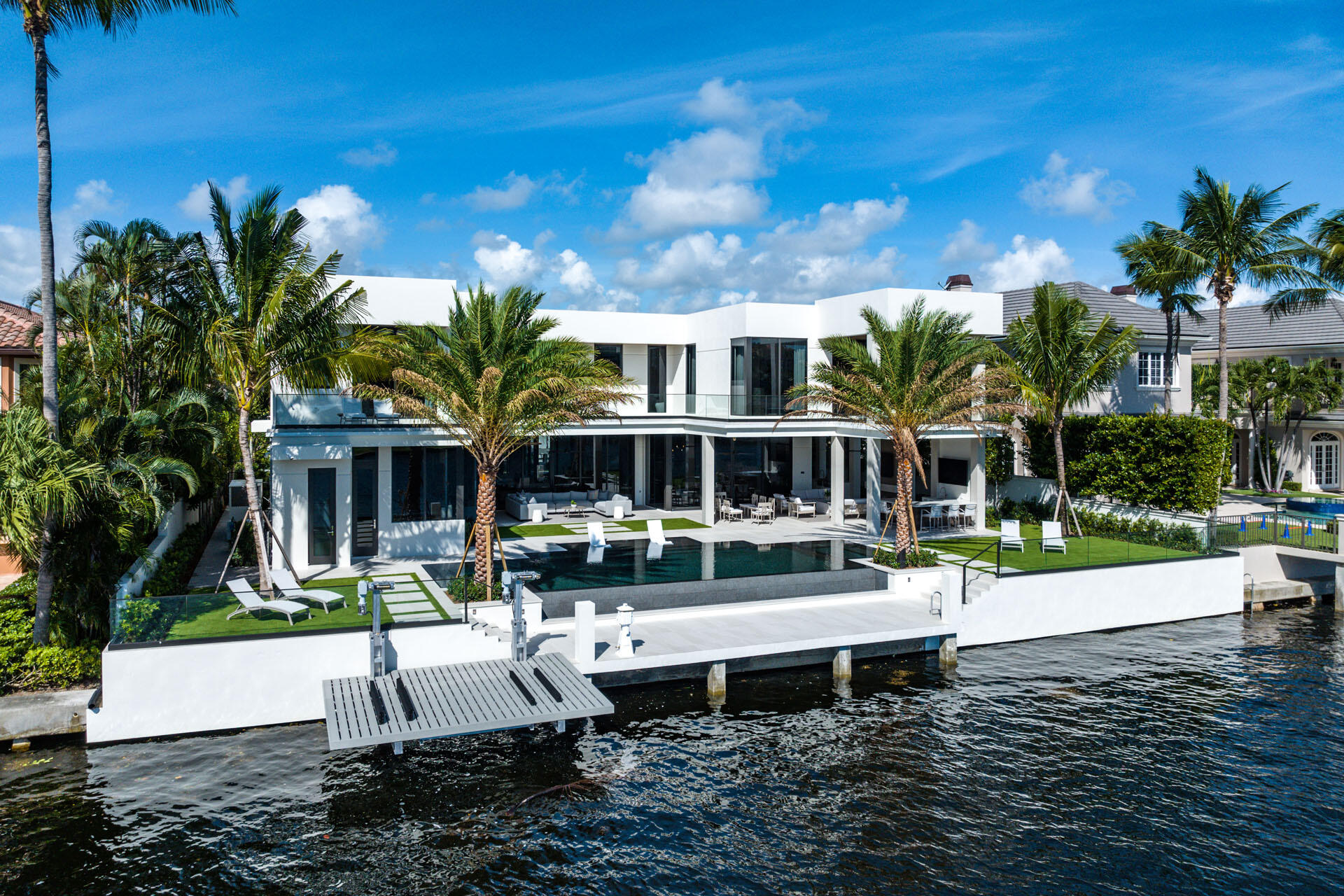 Welcome to 500 Alexander Palm Road-an Intracoastal turn-key Signature Estate by SRD Building Corp, perfectly positioned within Royal Palm Yacht & Country Club, Boca's most coveted community. Built in 2022, the home spans more than 8,200 square feet of beautifully designed, open, and airy living space. The five-bedroom residence features a 4-car plus golf-cart garage, a resort-grade pool and outdoor retreat, and 100 feet of premier Intracoastal frontage complete with a private dock and Jet Ski lift. Enhanced by full Crestron smart-home automation, advanced security features, and meticulous craftsmanship throughout, the property is offered fully furnished by the award-winning P&H Interiors--creating a seamless, move-in-ready waterfront experience.