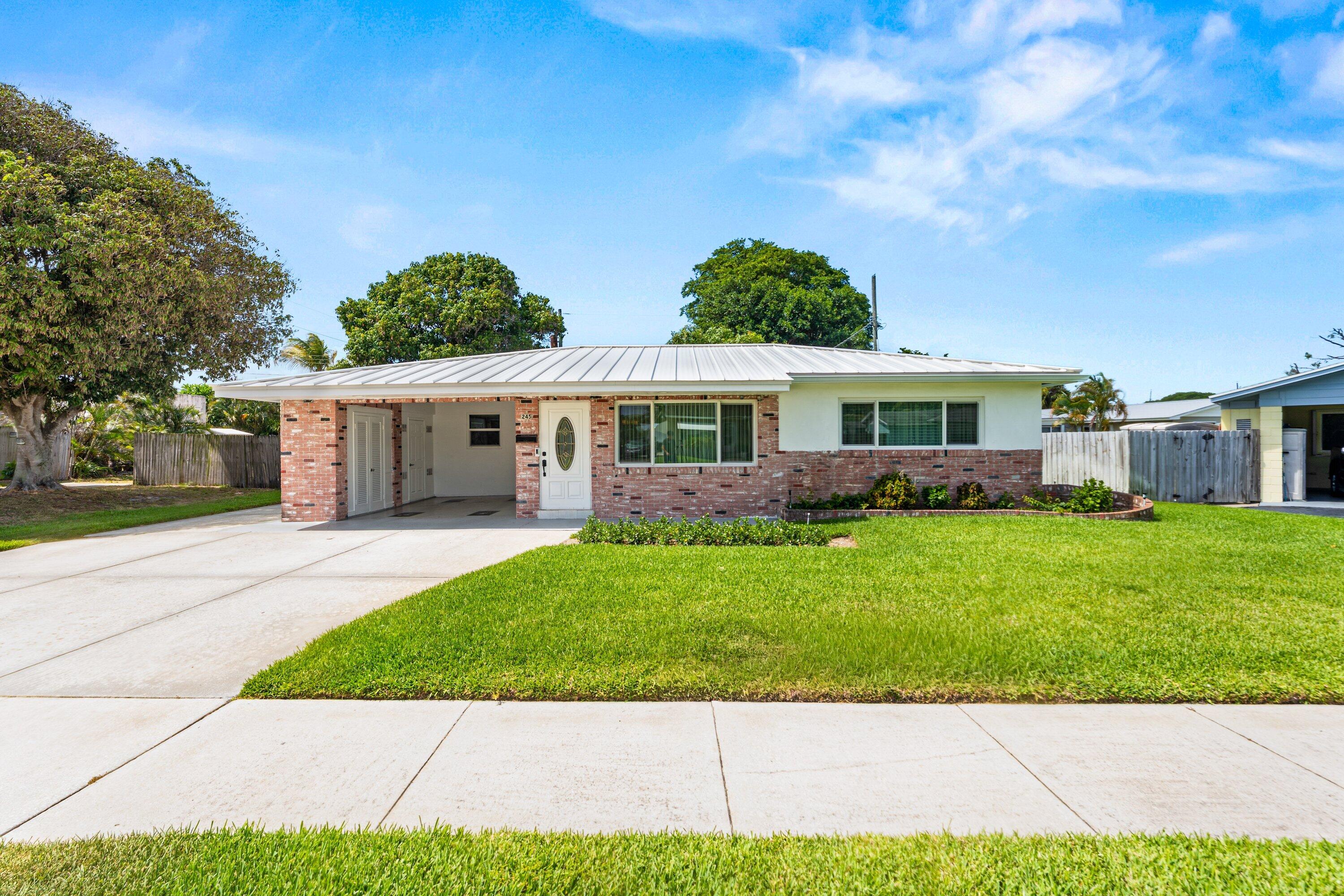 NEW METAL ROOF - NEW HURRICANE IMPACT WINDOWS - NO HOA - Welcome to this absolutely immaculate 2-bedroom, 2-bath home in the heart of Lake Park, Florida! Owned and lovingly maintained by the original owners, this home radiates pride of ownership from the moment you arrive. Exceptionally clean and truly move-in ready, it offers bright living spaces, spacious bedrooms, indoor washer and dryer, and a warm, inviting feel throughout. Major upgrades include a newer metal roof and full hurricane impact windows for peace of mind and long-term value. Outside, enjoy a large lot, covered carport, and a solid CBS exterior structure in the backyard perfect for storage, hobbies, or workspace needs. Conveniently located near parks, shopping and dining. Homes cared for this well rarely hit the market!