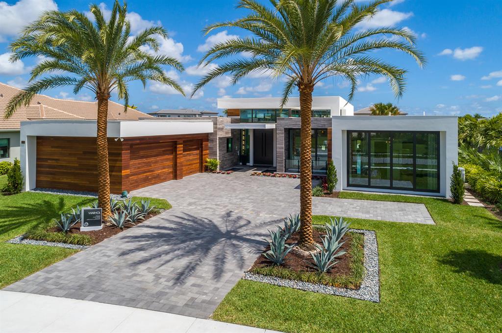 Modern one-story, open concept home with floor to ceiling windows/sliders throughout overlooking the stunning custom pool and beautiful lake. This home features a fabulous entertaining backyard with upgraded summer kitchen and custom pool with floating steps, water feature and bubblers. Some of the many highlights include: unique entry with water feature and 12' doors, 16' ceilings in living and dining areas, natural stone driveway/walkway, Ipe garage doors and extensive Ipe accents on exterior walls, modern gourmet kitchen with integrated appliances, spectacular modern master bath with floating vanities and walk-in integrated tub and shower overlooking the lanai.