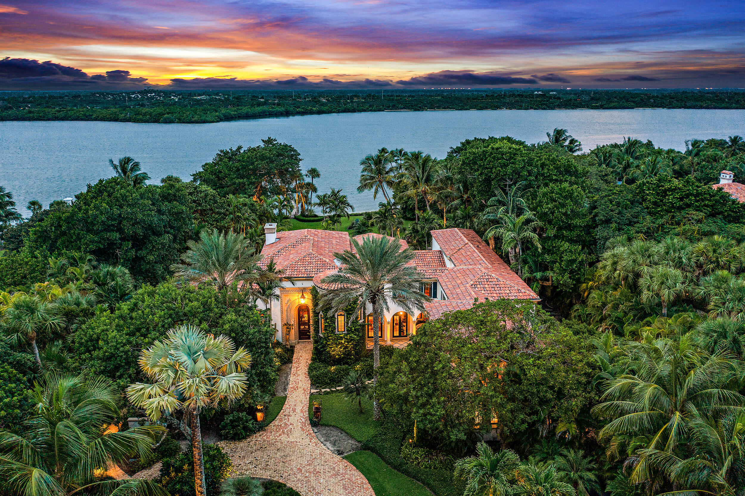 Grand Waterfront Estate with over 175' of Intracoastal Waterway.  As you enter this trophy property through the winding drive surrounded by lush tropical landscaping you will feel tranquility and awe.  The property is over 2 acres which is comprised of a main residence with 5 bedrooms, gym, theater, living room with fireplace, family room open to the kitchen. guest house with full eat-in kitchen, separate bedroom and bath and large family room, lastly a gate house with kitchen, bedroom, bath and family room.  Enjoy countless hours in the rear yard along your own white sandy beach, relaxing under a specimen Banyan tree, sprawling lawns and manicured landscaping.  This is a true masterpiece property and will not last.