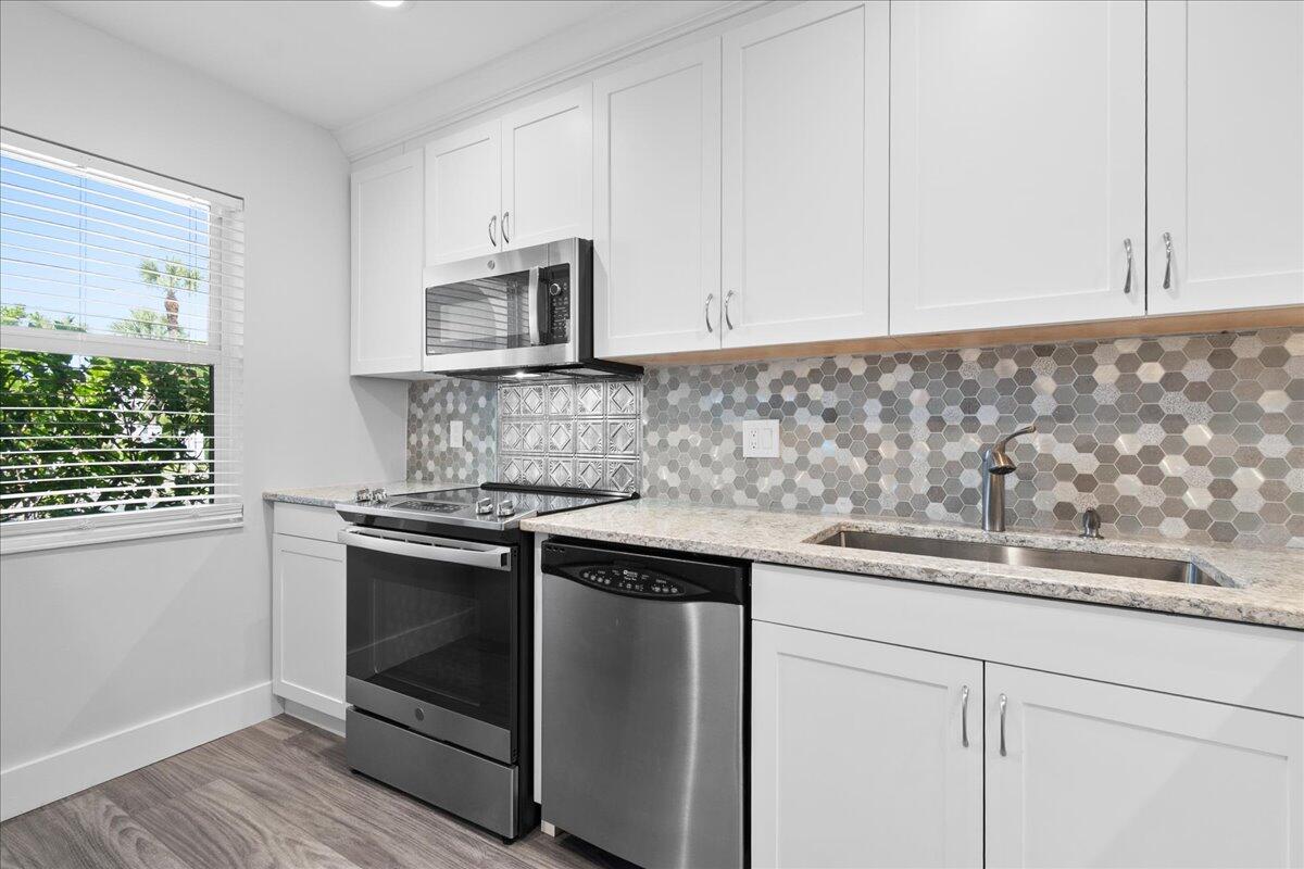 Stunning, fully updated modern unit in Golden Lakes Village — West Palm Beach's premier active 55+ community. This move-in-ready home features all stainless steel appliances, brand-new washer and dryer, and impact windows throughout for energy efficiency and peace of mind. Sleek, contemporary finishes deliver low-maintenance, turnkey living. Golden Lakes Village offers a resort-style lifestyle: multiple pools, tennis & pickleball, fitness center, clubhouse, billiards, on-site café, and a full calendar of social events. Beautifully manicured grounds, scenic lake views, and 24-hour security. Minutes from shopping, dining, medical, and Palm Beach's beaches. The active 55+ lifestyle you've been waiting for. Schedule your private showing today. Roof 2020 /AC 2021/WH 2007