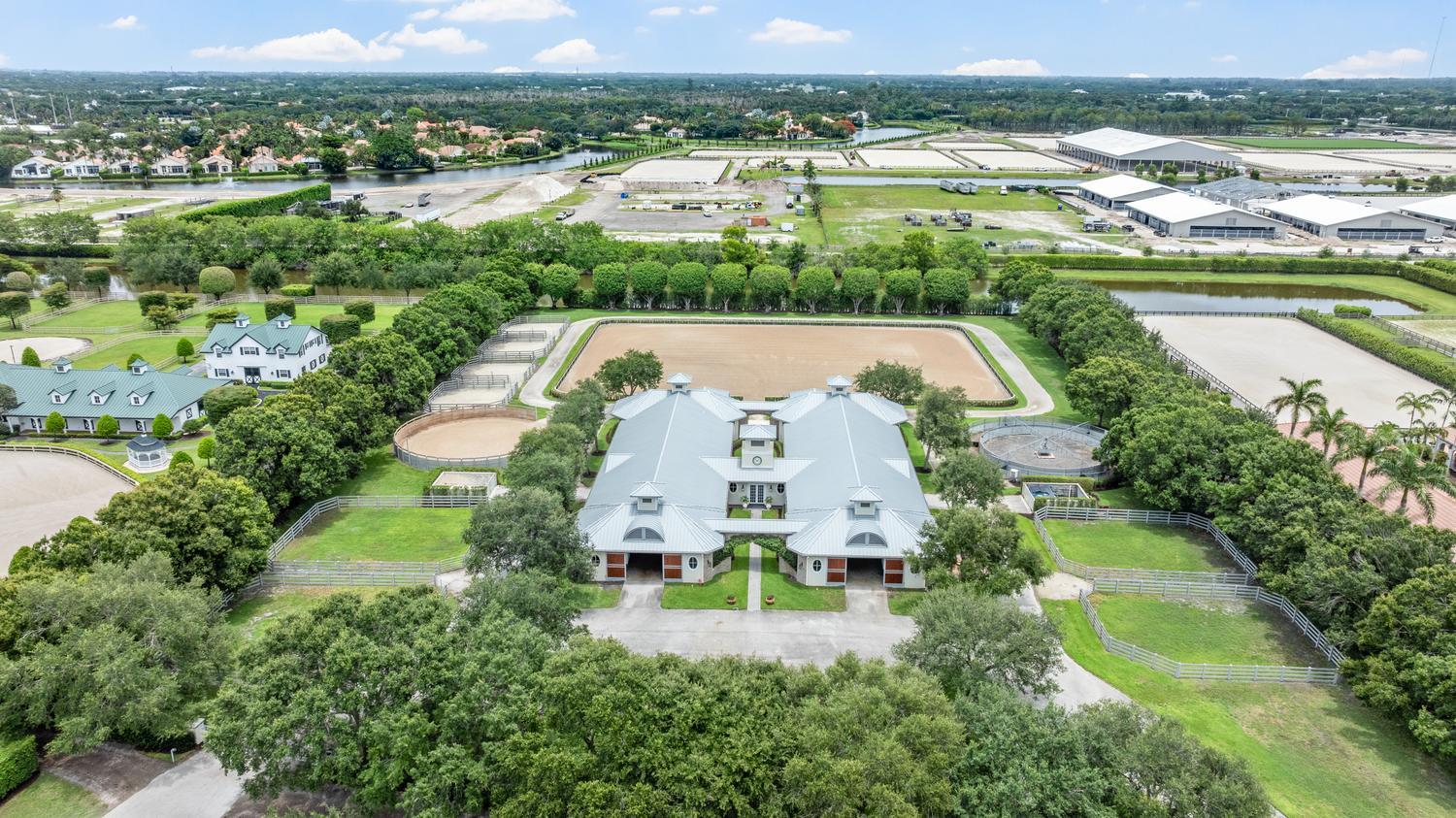 Offered for the first time in over 16 years, this premier estate in the heart of Grand Prix Village is one of Wellington's most admired equestrian properties. Designed by a true horseman to the highest standards, the farm seamlessly blends elegance, functionality, and privacy in a setting that is both stately and inviting. At the center of the property sits a beautifully designed 22-stall barn with two wide, airy aisles, complemented by thoughtfully appointed owner's and staff quarters. Every detail reflects quality craftsmanship and a deep understanding of the sport. The equestrian amenities are exceptional, highlighted by a 170' x 240' arena, ideal for top-level training and competition preparation. Additional features include a horse walker and nine well-maintained paddocks, round pen  and sand track around the arena offering both convenience and optimal care for the horses. Perfectly positioned only a short hack to both major Wellington International show grounds, This special property allows riders to move effortlessly between venues while enjoying the tranquility of a private farm. Always admired and rarely available, this is a truly rare opportunity to own a standout farm in one of the most sought-after equestrian communities in the world.