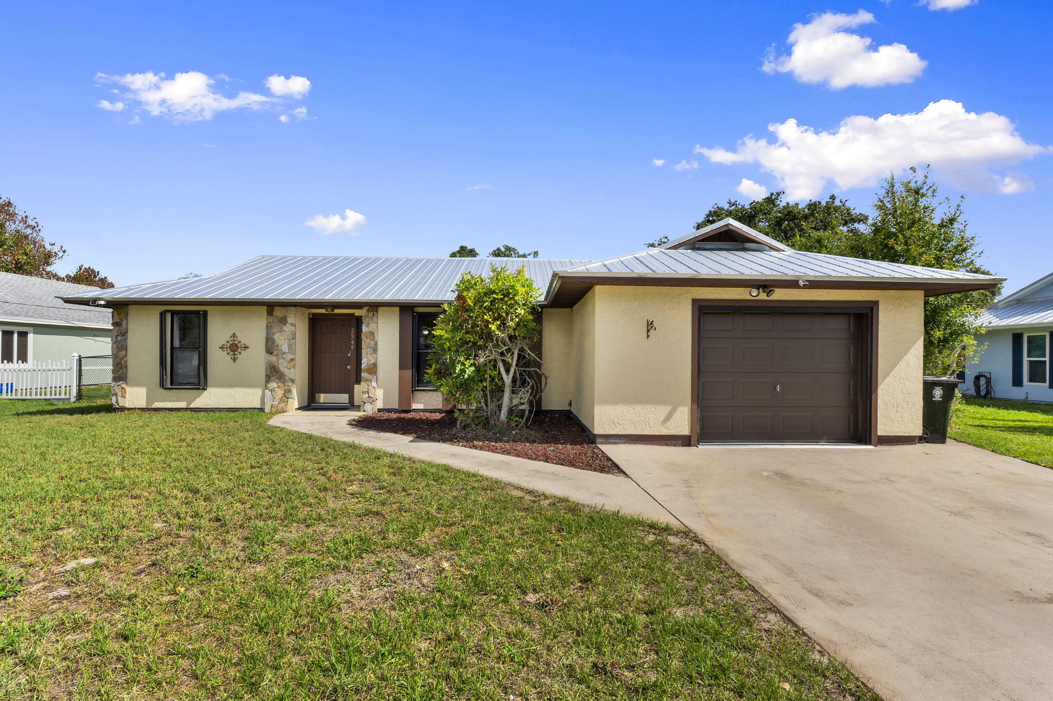 This 2-bedroom, 2-bath home is established in a quiet neighborhood with no HOA. The major updates are already done. 2023 metal roof, 2018 A/C, 2025 water heater, and accordion shutters on every window. Vaulted ceilings and a split floor plan give the space an open, easy feel, and the kitchen flows right into the Florida room through a classic pass-through window. Step outside to a fully fenced backyard complete with an outdoor shed and plenty of space to add a pool. With solid bones and endless opportunity to personalize, this home offers a fantastic opportunity to make it truly your own.