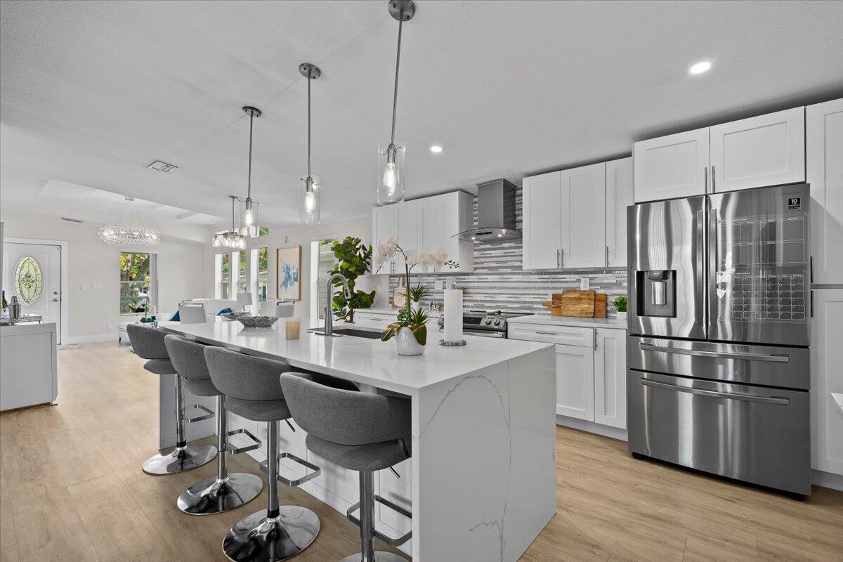 Beautifully renovated 3-bedroom, 2-bath home located in the highly desirable Meadows community in Palm Beach Gardens! This move-in-ready property features a stunning open-concept floor plan with luxury vinyl flooring throughout, a designer kitchen with quartz countertops, oversized island with seating, white shaker cabinetry, stainless steel appliances, wine cooler, modern backsplash, and upgraded lighting throughout. Spacious primary suite offers a private bath and generous closet space. Enjoy indoor/outdoor living with a covered front porch, paver driveway, attached carport, and private outdoor entertaining area perfect for relaxing or hosting guests. Meticulously maintained with updated finishes that give this home a true modern coastal feel. Conveniently located just minutes from I-95, The Gardens Mall, beaches, golf, shopping, dining, and Palm Beach International Airport.