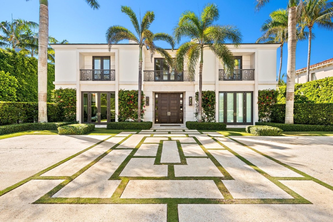 Welcome to an exquisite Palm Beach estate built in 2017, offering 6,823 sq ft of refined luxury and timeless design. This four-bedroom, five-and-a-half-bath masterpiece blends elegant architecture with impeccable craftsmanship. Step inside to discover soaring ceilings, sun-drenched living spaces, and seamless indoor-outdoor flow ideal for both intimate gatherings and grand entertaining. The gourmet kitchen features top-of-the-line appliances, custom cabinetry, and a spacious island. A striking onyx backlit bar with a wine refrigerator elevates the home’s ambiance. Outside, a resort-style pool surrounded by lush tropical landscaping provides a serene private retreat just two blocks from Mar-A-Lago. Experience the pinnacle of Palm Beach sophistication and coastal elegance.