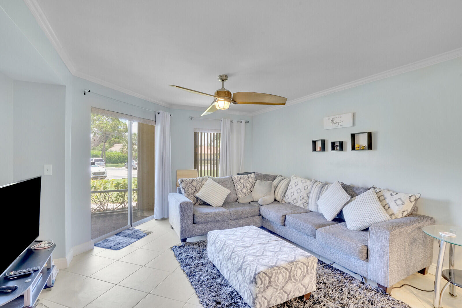 This bright and well-maintained unit offers an open layout with diagonal tile and laminate flooring, crown molding, and a spacious kitchen featuring granite countertops, a breakfast bar, and a stackable washer and dryer for added convenience. The primary suite includes a generous walk-in closet with built-ins, and the screened patio provides a comfortable outdoor space to unwind. AC 2020.