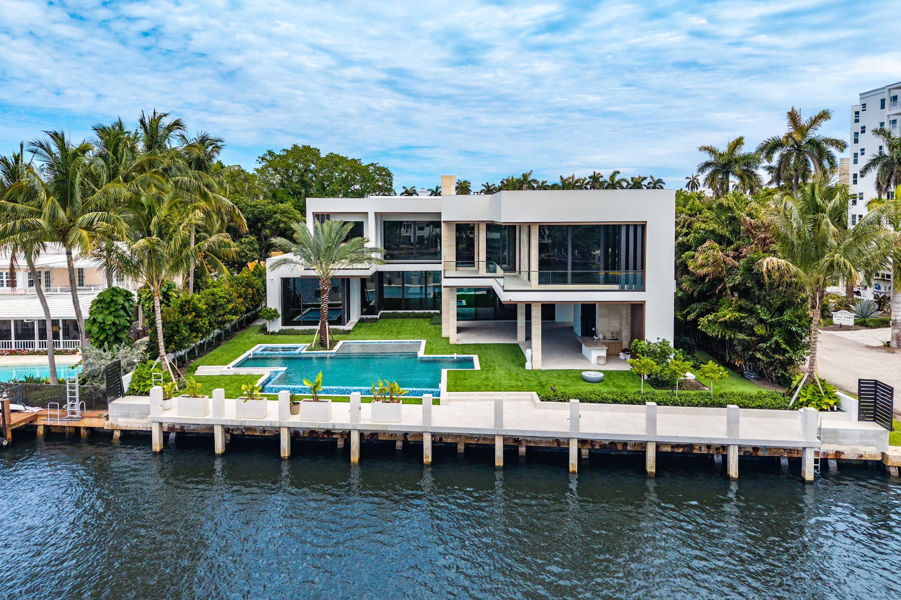 Built by award winning Azure Development. Exceptional Intracoastal estate situated on over half an acre with 111 feet of direct waterfront and a 90-foot concrete dock. Spanning 12,773 total square feet, the residence offers five bedrooms, seven full and two half bathrooms, a four-car plus golf cart garage, VIP suite, office, club room, theater, service kitchen, fitness room with steam room and sauna, elevator, and Gaggenau appliances. Outdoor living is highlighted by large lanai and an oversized infinity-edge pool with spa, sun shelf, and fire features.