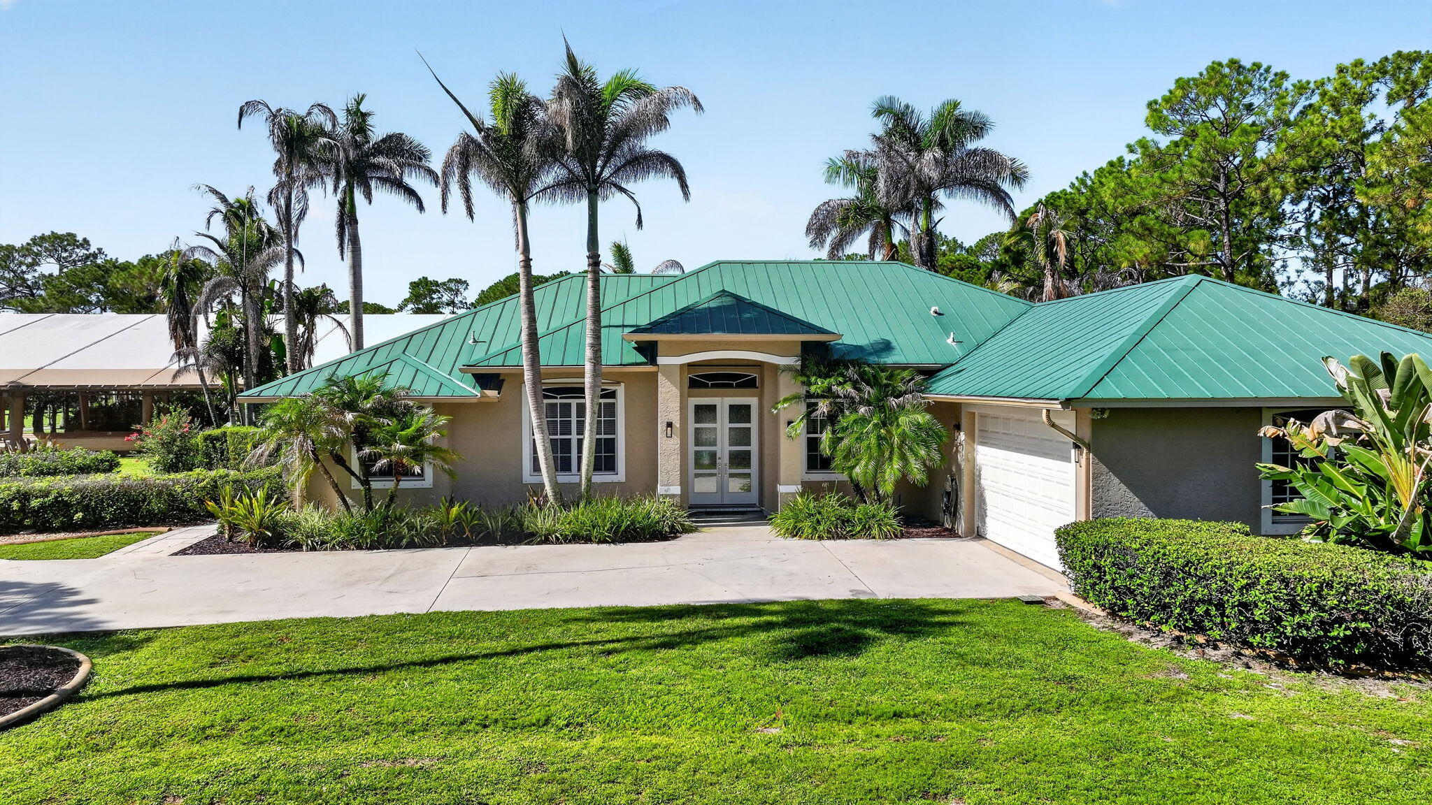 Palm City Farms Equestrian Estate | Endless Potential. A rare opportunity awaits at this working equestrian farm situated on 11.72 acres in Palm City Farms. Whether you're an equestrian professional, investor, or someone seeking a property with room to grow, this unique offering provides the perfect blend of functionality, flexibility, and future opportunity. Currently operating as a successful equestrian facility w/ 14 stalls, the property is ideally suited for dressage training, boarding, and a variety of equestrian disciplines w/ 100' x 220' covered arena w/ mirrors, ample space for additional barns, arenas, or RV, horse trailer, and equipment storage. The property offers strong investment potential while providing the flexibility to expand or customize it to suit your vision.  Extensive paved driveways and generous parking areas create a welcoming arrival while providing excellent accessibility for horse trailers, equipment, recreational vehicles, and guests. For the horses, plenty of turnout with 10 paddocks. The existing three-bedroom residence embraces Florida's sought-after indoor-outdoor lifestyle, opening onto an expansive terrace featuring a pool, relaxing spa, and Brazilian outdoor kitchen—an inviting setting for entertaining or unwinding. While comfortable and well-maintained, the residence is ideally suited for trainers, staff, or guests, providing the flexibility for a future owner to build a custom estate home while maintaining valuable on-site accommodations. Ideally located just minutes from major highways, scenic riding trails, shopping, dining, and everyday conveniences. Whether your vision is to expand an established equestrian operation, create a private estate, or generate income through boarding, training, and additional storage opportunities, this property offers the space, flexibility, and potential to bring that vision to life.