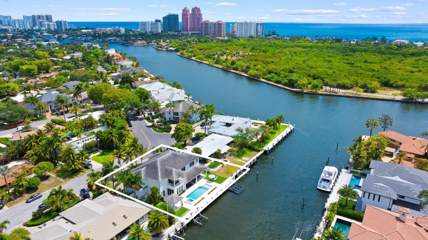 Experience waterfront luxury in prestigious Coral Ridge! Built-2019, this 5 bed, 5.1 bath two-story estate offers 4,935 sq ft of refined living on a 100' x 110' lot with 100’ of deep water frontage—just two homes from the point with no fixed bridges. Enjoy canal & Intracoastal views, a raised seawall, boat lift, and saltwater resort-style pool & spa. The open floor plan flows seamlessly to the outdoors through stacking sliders. A gourmet kitchen dazzles with a Wolf 6-burner gas range, Sub-Zero fridge/freezer, and outdoor kitchen for entertaining. Primary Bedroom offers a private balcony with endless water views, dual walk-in closets. Features remote screen enclosure on patio for seamless indoor/outdoor living, generator, EV-ready 3-car garage, and luxury finishes throughout.