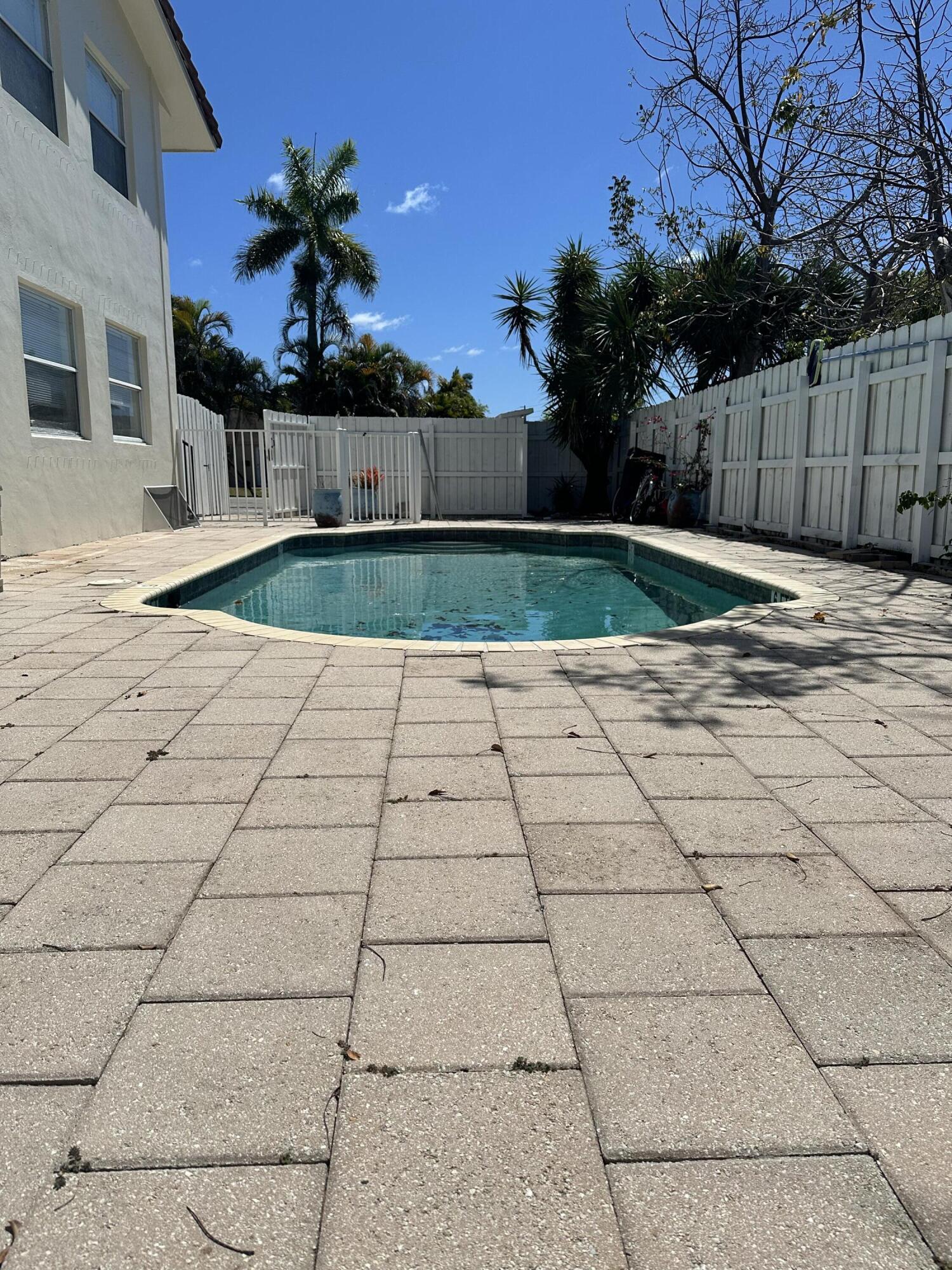 Available after August 1. Spacious 1-bedroom residence featuring two private patios, a fenced-in yard, and direct private access to the community pool. Includes one assigned parking space plus one guest parking space. Enjoy a private, comfortable setting with great outdoor space.