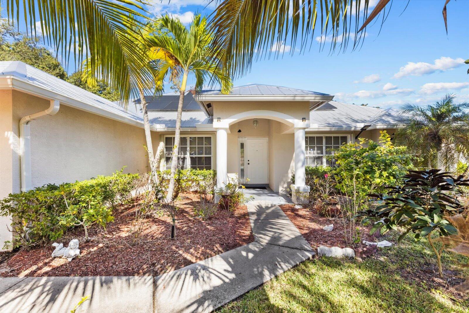 Beautifully improved home in Port St. Lucie with modern upgrades! Features metal roof (2022), solar panels for energy savings, screened-in pool & screened back patio. Lush landscaping w/ fruit trees. This well-maintained property offers low maintenance living with sustainable features & Florida outdoor lifestyle. Move-in ready with thoughtful improvements throughout the years. Perfect for buyers seeking energy efficiency & resort-style backyard living. Don't miss this gem!