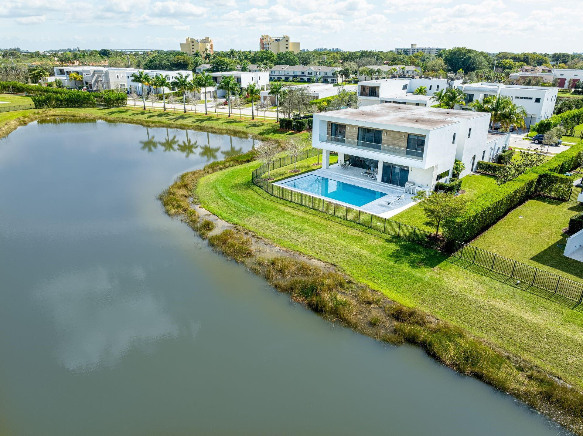 A modern masterpiece nestled within the exclusive gated enclave of Botaniko Estates in Weston. Newly constructed and designed by world-renowned architect Chad Oppenheim, this remarkable residence sits on a premier corner lot with beautiful lake views. The spacious open-concept floor plan is filled with natural light and offers over 7,283 SF of total construction (4,301 SF under air & 5,044 adjusted SF). The home features 5 ensuite bedrooms, a private office, and 6.5 bathrooms. Designed for both luxury living and entertaining, the residence includes an oversized 3-car garage, extended driveway, gourmet chef-inspired kitchen with gas stove, top-of-the-line appliances, wine cellar, and built-in coffee machine. Step outside to your private outdoor oasis featuring an oversized pool!