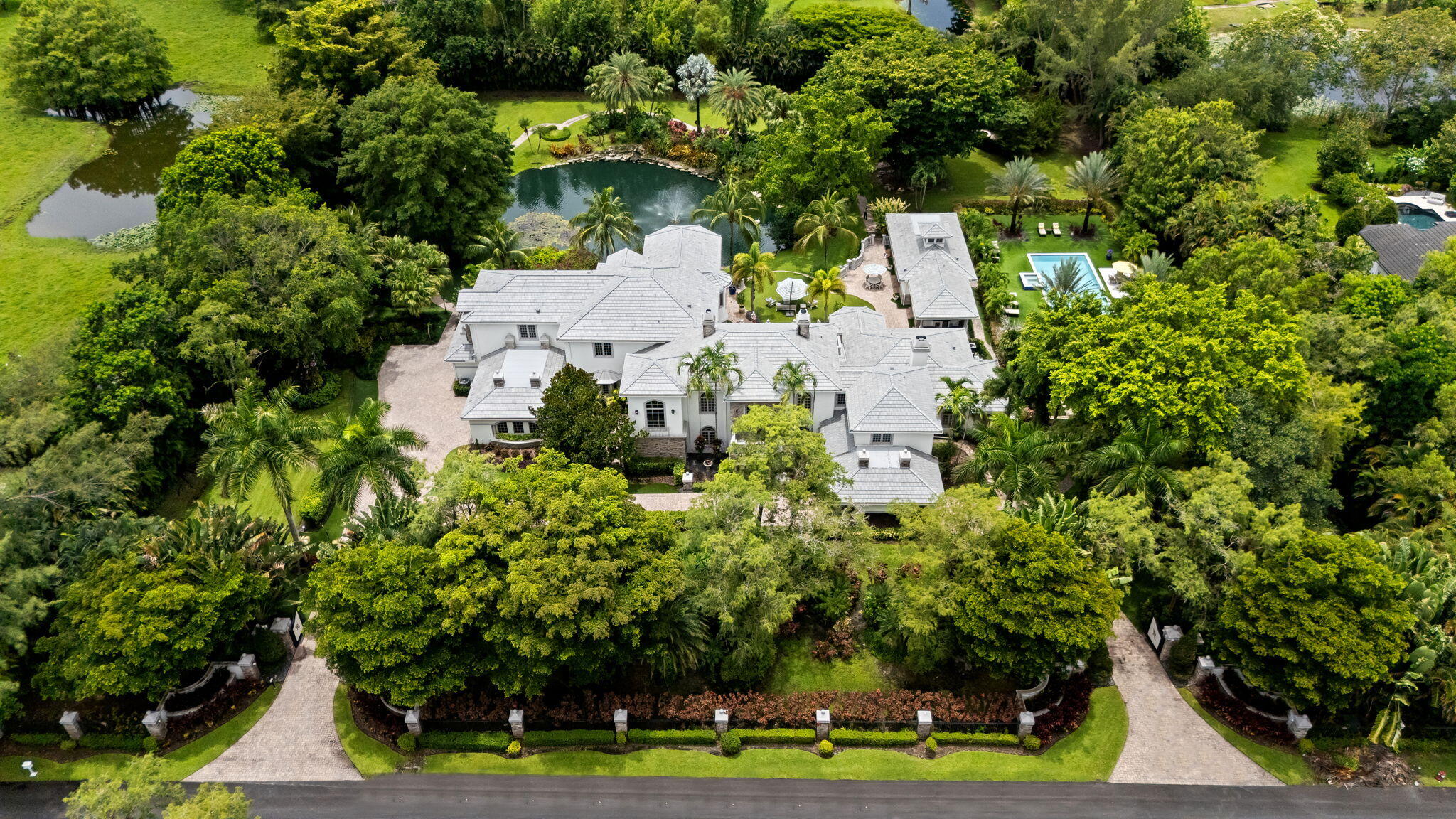 Spectacular, Grande Manor on 3 sprawling acres completely fenced and gated entrance with private lake, gazebo, fire pit, guest house. and gym. New roof in 2026, new 2025 custom pool. This estate offers 16,578 + sq ft of total living space, including 6 bedrooms, 6 full and 2 half baths plus office, elevator, theater, wine cellar, loft, 3 wet bars, 3 gas fireplaces, and 4 car garage. Professionally decorated with  attention to detail and the finest materials
