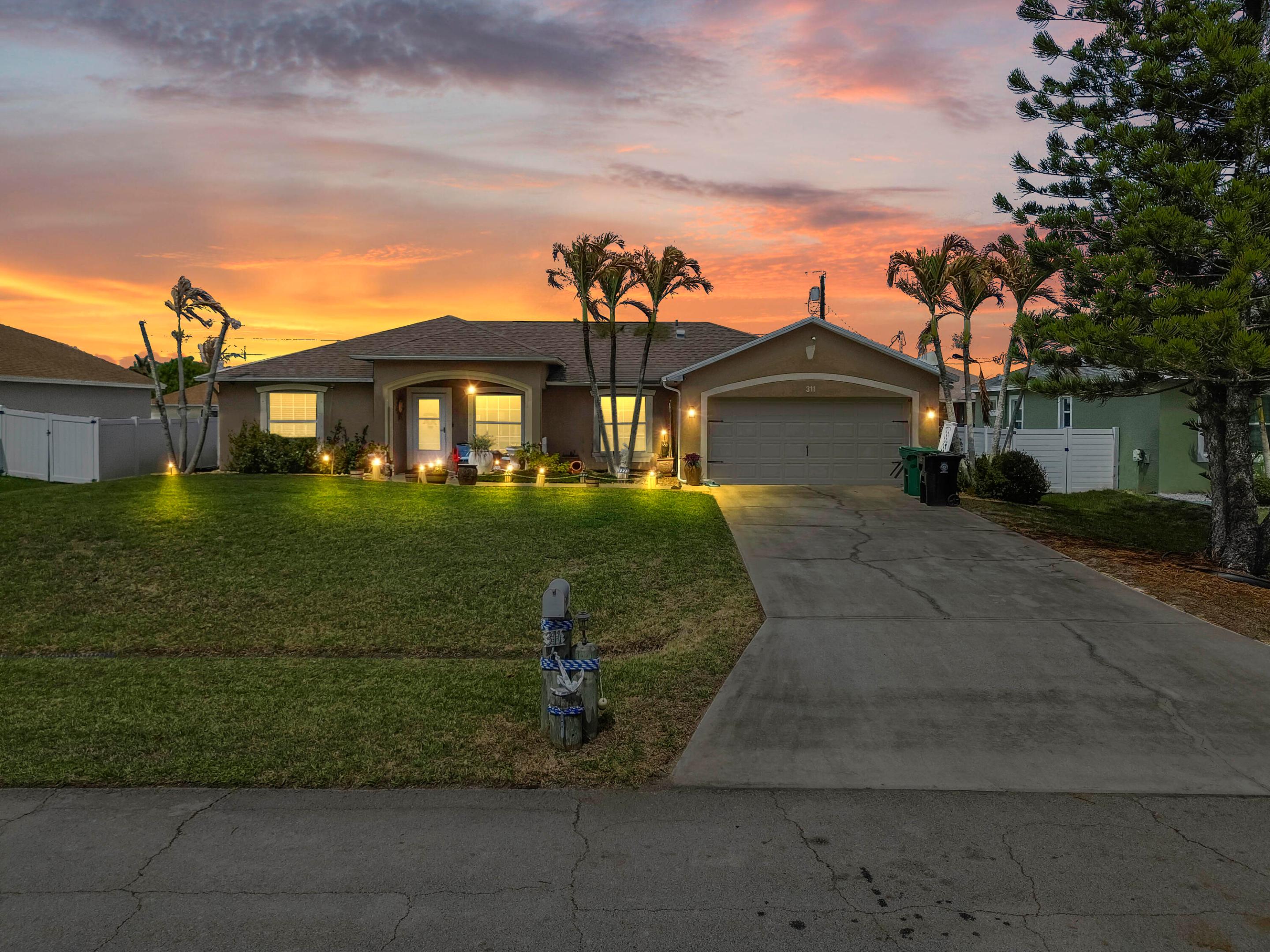 Welcome to your slice of paradise at 311 SW Dustin Avenue, this home boast 3 bedrooms, large den, 2 full bathrooms and a pool, all nestled in a peaceful and picturesque Port St. Lucie neighborhood. From the moment you arrive, the charming curb appeal inviting front pathway set a welcoming tone. Step inside to discover a bright and thoughtfully designed floor plan featuring easy-to-maintain tile flooring throughout the main living areas. The living spaces are warm and comfortable, boasting unique touches like a striking wood-paneled accent wall and plenty of natural light, creating the perfect environment for both relaxing with family and entertaining guests. At the heart of the home is a beautifully appointed kitchen that will delight any home chef. It features crisp white cabinetry, stunning stone countertops, modern stainless steel appliances, and a convenient center island that provides excellent prep space. The home offers generously sized, uniquely styled bedrooms that serve as comfortable retreats for family and guests alike. The bathrooms are equally impressive, featuring elegant tile work, with a standout soaking tub offering a spa-like atmosphere to unwind after a long day.  Step outside and prepare to be amazed by the ultimate Florida backyard oasis. The expansive, fully fenced backyard is an entertainer's dream, centered around a magnificent private pool surrounded by gorgeous brick pavers. You can enjoy year-round outdoor living in the spacious screened-in lanai, complete with a covered patio area perfectly set up for weekend barbecues and al fresco dining. Complete with a handy storage shed and plenty of space to lounge under the sun, this private outdoor retreat is ready for you to make lasting memories.