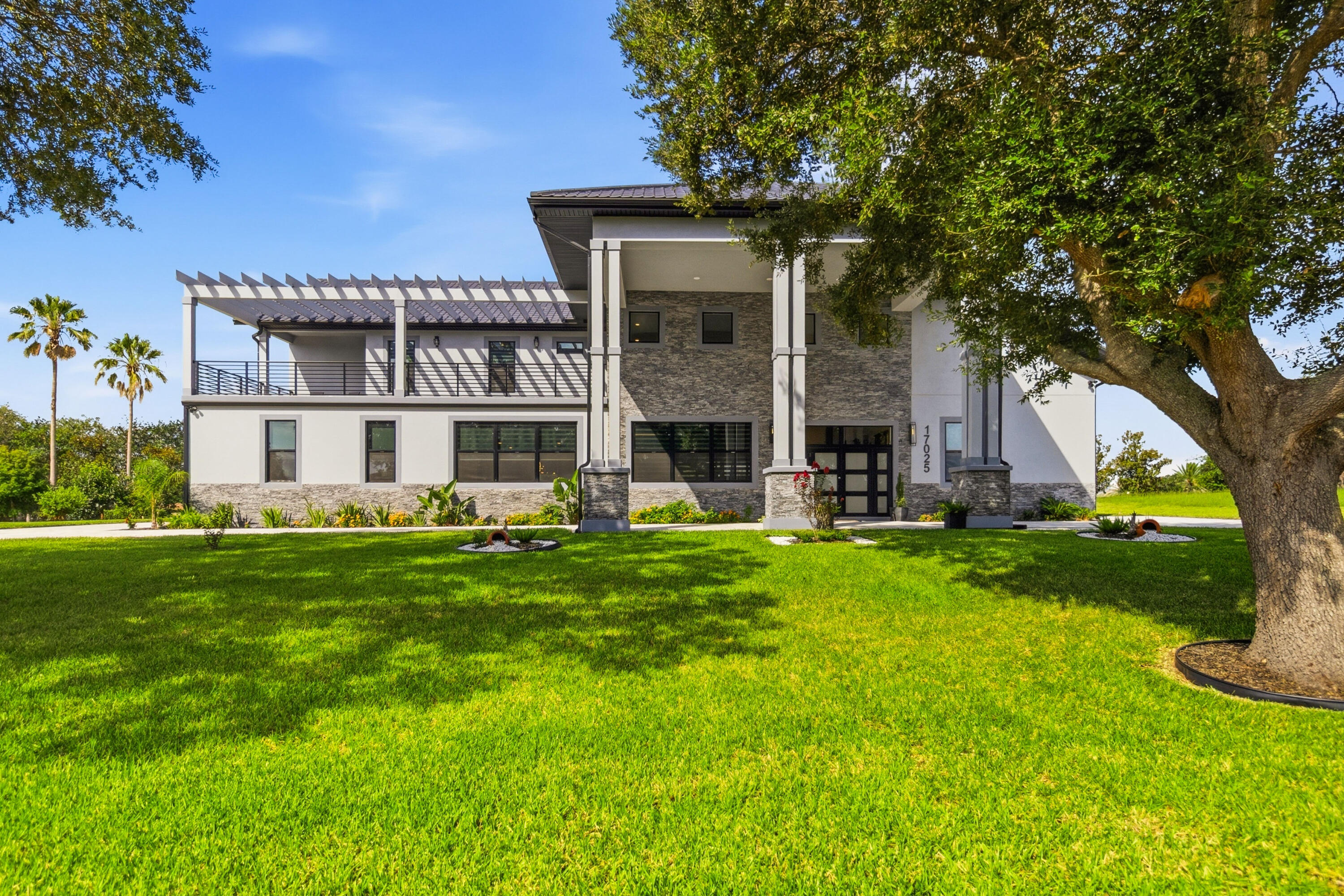 Skip the wait for new construction. This custom contemporary estate, less than one year old, offers over 7,000 SF of exceptional design in an exclusive gated community with Chain of Lakes access. Highlights include a dramatic two-story great room, floating glass staircase, chef's kitchen with waterfall Calacatta marble island, Café appliances, luxurious primary suite with spa bath, private lounge and flex room, ensuite bedrooms, home theater, media room, and attached guest suite with full kitchen, laundry, and private entrance. Outdoor living features a resort-style pool, summer kitchen, fire pit, retractable screens, and permanent rear park views. Community boat ramp, dock, and fishing pier included.  Skip the wait for new construction. This extraordinary custom contemporary estate, completed less than one year ago, combines striking modern architecture with exceptional craftsmanship in an exclusive gated community offering coveted Chain of Lakes access.  Spanning more than 7,000 square feet, the home was thoughtfully designed with both everyday living and grand-scale entertaining in mind. From the moment you enter, you're welcomed by a breathtaking two-story great room featuring soaring ceilings, a dramatic floating staircase with glass railings, designer lighting, and walls of windows that fill the home with natural light.  At the heart of the home is a stunning chef's kitchen showcasing matte black cabinetry accented with warm wood details, a waterfall-edge Calacatta marble island, premium Café appliances, brushed gold fixtures, and abundant workspace for entertaining. The adjacent dining area creates an elegant setting for both intimate dinners and larger gatherings.  The second-floor primary suite offers a true private retreat with wide-plank hardwood flooring, custom designer finishes, and a spa-inspired bath featuring floor-to-ceiling Calacatta marble, a freestanding soaking tub, oversized frameless glass shower, dual vanities, and premium fixtures. A private sitting lounge, flex room ideal for a home office, fitness studio, or nursery, and a dedicated laundry room complete this luxurious owner's level.  Every additional bedroom is generously sized and features its own ensuite bath and oversized walk-in closet, providing exceptional comfort and privacy for family and guests alike.  Designed for entertaining, the home also includes a dedicated home theater with tiered seating, a separate media room, and exceptional storage throughout.  Outdoor living is equally impressive. A covered lanai with a dramatic floor-to-ceiling stone feature wall opens to a fully equipped summer kitchen and fire pit lounge, all enhanced by automatic retractable screens. Beyond, the resort-style pool with swim shelf is surrounded by expansive travertine decking and lush tropical landscaping, all overlooking protected green space that ensures no rear neighbors now or in the future.  One of the home's most unique features is the fully self-contained guest suite, complete with its own private entrance, full kitchen, living and dining areas, washer and dryer, and complete privacy—ideal for multigenerational living, extended guests, or a private retreat.  All appliances convey with the sale. Select furnishings may be available separately, providing the opportunity for a seamless turnkey transition.  Residents enjoy exclusive access to the Chain of Lakes through the community boat ramp, covered dock, and fishing pier while remaining conveniently located approximately 45 minutes from Orlando International Airport, Walt Disney World, and Central Florida's premier attractions, with easy access to Florida's Turnpike and Highway 47.  This is a rare opportunity to own a nearly new custom luxury estate where every detail has already been thoughtfully designed and flawlessly executed.