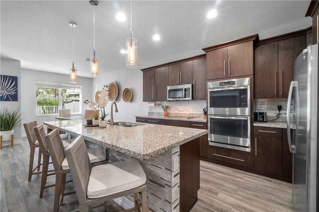 Spectacular Mosta model, 3BR, 2.5Bth, bar area, loft, fenced-in back yard & 2-car garage.  Shows like a model home!  No carpet throughout, highly upgraded. Impact windows and doors. Light and bright with a gourmet kitchen, large island, and breakfast area. Entertainers delight with indoor-outdoor living, spacious fenced in backyard. Light fixtures and entertainment center included. Upstairs you will find your large main bedroom with two walk in closets, private balcony overlooking pool and garden, main bath has separate tub and shower. Two other spacious bedrooms with walk-in closets, large loft area, and laundry room. Gated community, with dog park, pool & playground.  All in East Boca. See Supplements for HOA app and info.