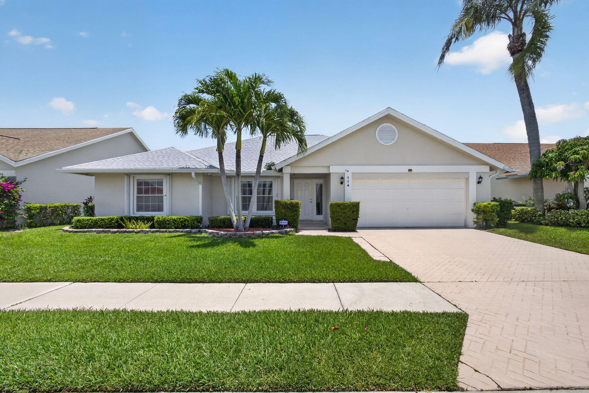 Welcome to 114 Palomino Drive, a beautifully cared for Jupiter home set on the Golf Club of Jupiter with peaceful golf course views in the sought after Eagle Ridge section of Indian Creek. BRAND NEW 2026 roof and impact windows provide valuable peace of mind, while natural light, vaulted ceilings, and an inviting layout create a warm, comfortable feel throughout. Inside you'll find 3 bedrooms, 2 baths, travertine marble flooring, an updated kitchen with Moldavite-Quartzite countertops and 2023 stainless-steel appliances, and a refreshed primary bath. The split floor plan offers privacy and easy everyday living. Step outside to the screened patio and enjoy quiet mornings, afternoon breezes, and relaxing golf course views.  Additional features include a 2020 AC, 2020 water heater, accordion shutters, a 2-car garage, security cameras, sprinkler system, brand new 2026 gutters, attic storage, and HOA maintained lawn care. Ideally located near Jupiter beaches, golf, parks, shopping, and dining, this home offers comfort, convenience, and classic Florida living in one of Jupiter's most loved communities.