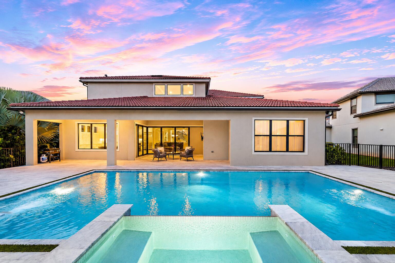 Welcome to this stunning luxury residence in Sonoma Isles, Jupiter, offering 5,134 square feet of pristine, refined living space across two thoughtfully designed stories. The panoramic views of the lake provide a beautiful backdrop for this elegant home. Featuring six generously appointed bedrooms, six full bathrooms, and one half-bath, this remarkable home combines sophisticated design, luxury finishes, and effortless Florida living in one of Jupiter's most sought-after communities.  Bathed in natural light, the open-concept floor plan showcases exquisite custom architectural details, including arched windows, extensive molding throughout, coffered ceilings, plantation shutters, elegant chandeliers, designer pendant lighting, and custom tile work. The chef-inspired kitchen serves as the heart of the home, featuring upgraded KitchenAid appliances, natural gas cooking, a large center island, and seamless flow into the spacious living and dining areas, perfect for entertaining and everyday living. A custom media room provides a dedicated space for relaxation and entertainment, while the extended primary suite offers a luxurious private retreat. The home's expanded lanai creates a seamless transition to outdoor living, where breathtaking waterfront views set the stage for a true resort-style experience.  Step outside to your private backyard oasis featuring a heated saltwater pool with LED lighting, a stunning sand-blasted marble pool deck, and ample space for lounging and entertaining. A two-zone speaker system enhances both indoor and outdoor living, creating the perfect atmosphere for gatherings large and small. Completing the home is a spacious three-car garage providing secure parking and abundant storage. Combining timeless elegance, exceptional craftsmanship, and premium waterfront living, this extraordinary Sonoma Isles residence offers a rare opportunity to enjoy luxury at its finest. Residents of Sonoma Isles enjoy an exceptional array of resort-style amenities, including a beautifully appointed clubhouse, state-of-the-art fitness center, resort-style swimming pool and spa, tennis and pickleball courts, fire pit, social and activities rooms, covered lanai, and a children's tot lot. Meticulously maintained common areas and lush landscaping create a welcoming, resort-inspired atmosphere throughout the community.