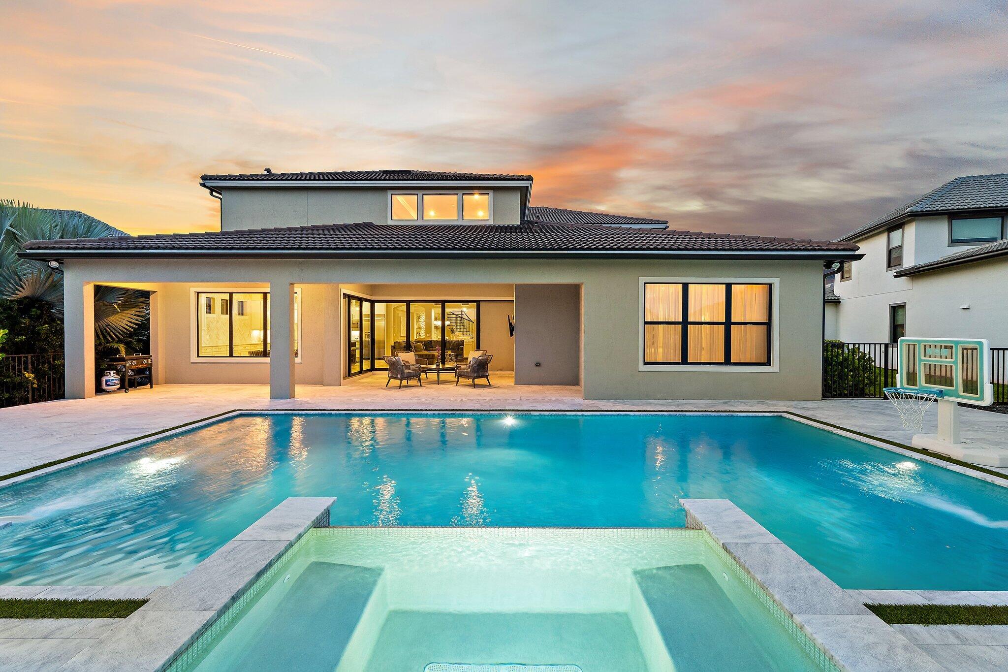 Welcome to this stunning luxury residence in Sonoma Isles, Jupiter, offering 5,134 square feet of pristine, refined living space across two thoughtfully designed stories. The panoramic views of the lake provide a beautiful backdrop for this elegant home. Featuring six generously appointed bedrooms, six full bathrooms, and one half-bath, this remarkable home combines sophisticated design, luxury finishes, and effortless Florida living in one of Jupiter's most sought-after communities.  Bathed in natural light, the open-concept floor plan showcases exquisite custom architectural details, including arched windows, extensive molding throughout, coffered ceilings, plantation shutters, elegant chandeliers, designer pendant lighting, and custom tile work. The chef-inspired kitchen serves as the heart of the home, featuring upgraded KitchenAid appliances, natural gas cooking, a large center island, and seamless flow into the spacious living and dining areas, perfect for entertaining and everyday living. A custom media room provides a dedicated space for relaxation and entertainment, while the extended primary suite offers a luxurious private retreat. The home's expanded lanai creates a seamless transition to outdoor living, where breathtaking waterfront views set the stage for a true resort-style experience.  Step outside to your private backyard oasis featuring a heated saltwater pool with LED lighting, a stunning sand-blasted marble pool deck, and ample space for lounging and entertaining. A two-zone speaker system enhances both indoor and outdoor living, creating the perfect atmosphere for gatherings large and small. Completing the home is a spacious three-car garage providing secure parking and abundant storage. Combining timeless elegance, exceptional craftsmanship, and premium waterfront living, this extraordinary Sonoma Isles residence offers a rare opportunity to enjoy luxury at its finest. Residents of Sonoma Isles enjoy an exceptional array of resort-style amenities, including a beautifully appointed clubhouse, state-of-the-art fitness center, resort-style swimming pool and spa, tennis and pickleball courts, fire pit, social and activities rooms, covered lanai, and a children's tot lot. Meticulously maintained common areas and lush landscaping create a welcoming, resort-inspired atmosphere throughout the community.