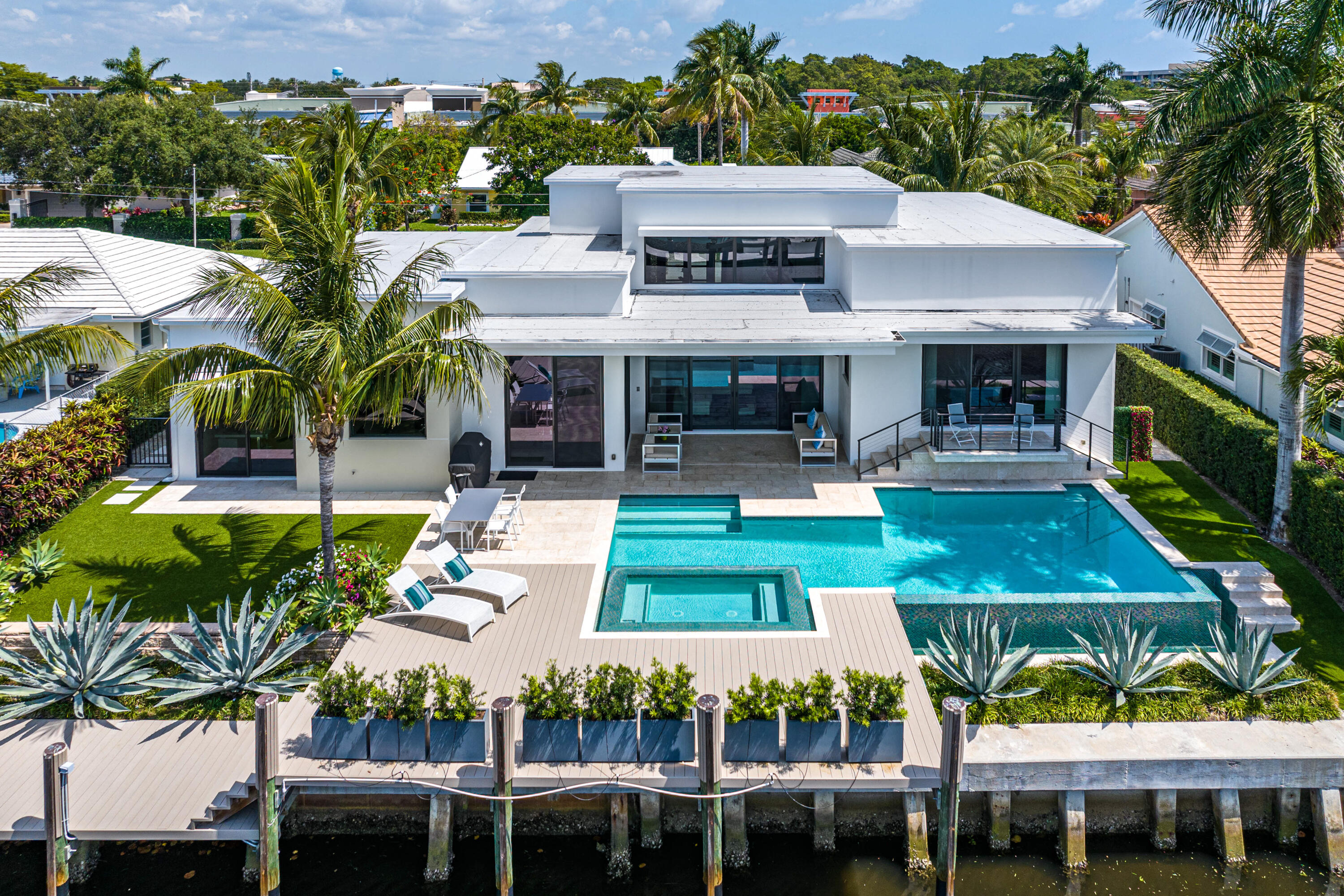 Waterfront Modern | Whether arriving by car or boat, 920 McCleary Street greets visitors with a feeling that can only be attained when a home blends water and land in harmony: the ability to take a deep breath and luxuriate in the satisfaction of waterfront living. Located directly on a wide canal with access to the Intracoastal Waterway, this impressive 2018 construction comprises 3 beds, 4.5 baths, an office/possible 4th bedroom, and 4,065 total SF, 3,080 of which are under air. Crafted with deeply intentional design that blends the lustrous modernity of metal and glass with serene organic touches like tiled accent walls, copious natural light, and waterfront views, this is a south-facing waterfront home that stands out even in Tropic Isle, one of Delray Beach's most sought-after enclave After entering through the foyer, visitors can take a few steps down and sink into the cozy recessed living room, where it's impossible not to admire the chic, artistic inset shelving built into the walls. Once inside, natural light can be found from any direction  this is a home steeped in bright organic tones, with extensive windows in every bedroom, bathroom and living space that perfectly illuminate its refined aesthetic. Through its large sliding glass doors, the room opens to the patio, pool, and canal, and beckons to the home's immaculate outdoor spaces. A travertine patio overlooks the luxurious resort-style infinity edge pool with champagne spa, fitted with a new heater. Lush landscaping and potted plants elevate the all-turf backyard into a verdant oasis, and just beyond the pool is the dock, equipped with water and electric and prewired for lighting, with all-weather PVC decking to withstand the elements.  

Form and function meet in the sleek and lavish kitchen, with its quartz countertops, soft-close Canadian marine grade cabinetry by Neff, and designer backsplash. No expense was spared in equipping it for the needs of any home chef, as the space boasts Miele appliances along with dual sinks, disposals, and dishwashers, in addition to a wine cooler, dedicated knife drawer, and a hidden coffee bar. The kitchen island opens up directly into the dining area, lending unity to the space when entertaining guests.  

The primary suite leaves nothing to be desired, and boasts a built-in coffee bar with shelving, cove ceiling details, and a private terrace with water views. Additional comforts include custom built-in shelving and a washer and dryer with built-in hampers in the primary closet, along with an opulent primary bathroom with a gorgeous marble accent wall, Porcelanosa porcelain flooring, dual sinks with quartz countertops, a freestanding soaking tub, and designer basketweave tile in the dual shower. 

Each of the home's two guest bedrooms includes its own spacious ensuite dual sink bathroom and closet, and a powder room lies just off the living room for visitors. A full fifth "cabana" bath with outdoor entrance lies just off the kitchen making indoor/outdoor entertaining easy and carefree. 

Smart home features abound in this contemporary space, with four integrated security cameras, a surround sound system, LED colored lighting, an electric fireplace, and much more. Additional amenities include a 2-car garage, impact glass windows, doors, and sliders, 2 tankless water heaters, motorized shades, and the home is generator ready with a transfer switch pre-installed.  

920 McCleary Street is a luxurious modern retreat that still leaves much to your imagination. It remains a blank canvas for you to display your treasures in its art niches and dock your vessel on the canal. 

The information published and provided including but not limited to prices, measurements, square footages, lot sizes, features, finishes, and calculations are subject to errors, omissions or changes without notice.  All such information should be independently verified.  All parties should perform their own due diligence to verify all information.