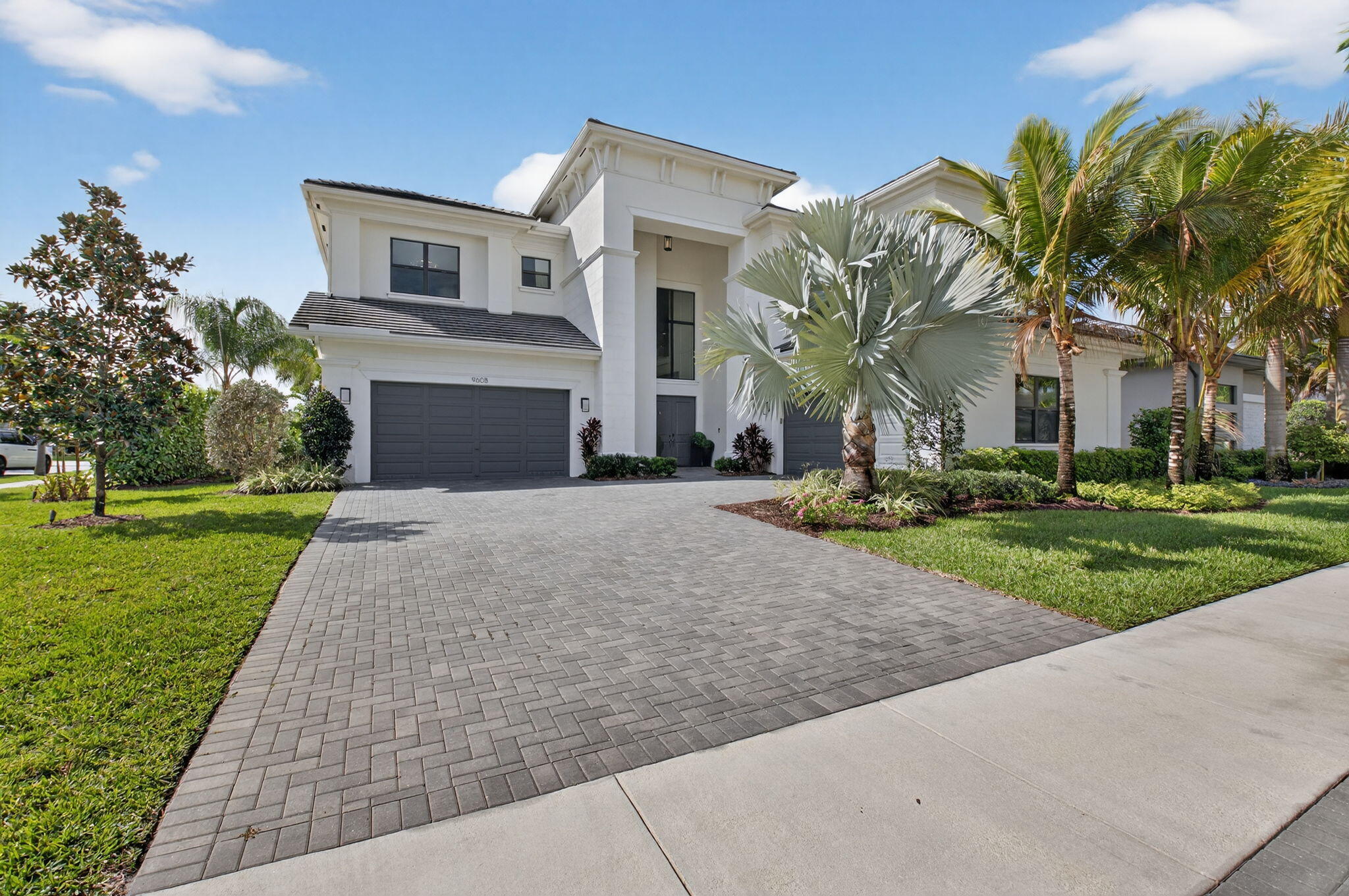 This stunning Riverside model with a coastal transitional elevation showcases exceptional design, thoughtful upgrades, & a beautifully curated indoor-outdoor lifestyle. Original enhancements include a resort-style outdoor oasis, creating a private retreat ideal for entertaining & relaxation. The backyard features a fully equipped outdoor kitchen, artificial turf, decorative fountains, & lush professional landscaping, along with a custom pergola with adjustable louvers offering both sun & shade throughout the day.  Additionally this home has been significantly upgraded with extensive architectural & designer features throughout: a striking glass staircase, custom wall moldings in the foyer & staircase, & an illuminated coffered ceiling in the living room create a dramatic & sophisticated interior. Other enhancements include custom millwork, a built-in media wall, glass-enclosed office, dining room wine display, & designer lighting throughout, including a John Richards chandelier & Eichholtz fixtures. The kitchen has been refined with custom wood panel cabinetry detailing, a custom exhaust hood, pull-out drawers & a double garbage pull-out system. The primary suite features a Venetian plaster accent wall with fireplace, decorative moldings, & motorized blackout drapery.   Additional highlights include Sonos audio, Lutron lighting automation, integrated WiFi access points, security features, upgraded closets, designer wallpapers by Trussardi & Phillip Jeffries, & enhanced mechanical systems with UV air purification.   Residents of Boca Bridges enjoy world-class amenities including a resort-style clubhouse, pools, fitness center, tennis, pickleball, dining, & a vibrant social lifestyle.  Exclusions: scent machine, water machine, Athena chandelier.