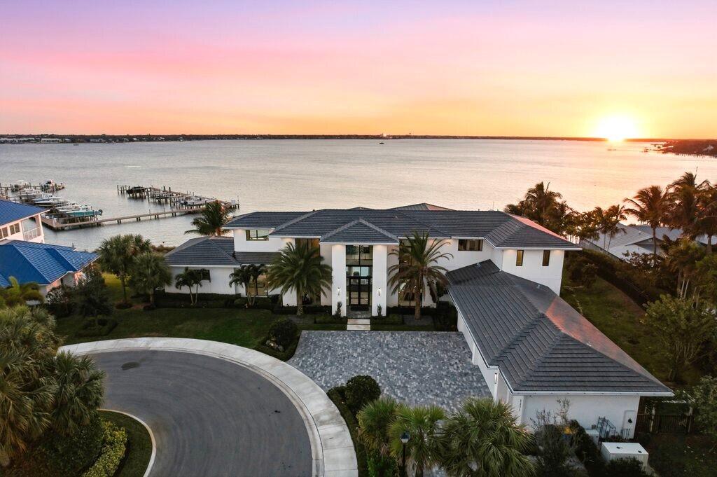 One-of-a-kind legacy custom 2022 built home surrounded by spectacular waterfront views atop an elevated .97 acre property.   Designed for family and entertaining living the home features endless amenities.  This 2 story home provides 6,651sqft under air and a spacious 9,350 sqft  under roof.  5BR, Den, 5 full bath and 2 half baths, Club room, loft and elevator.  Four (4) car  air conditioned garage plus golf cart garage.  A 50' dock with 20klb cradle lift is located at the community marina includes water and electric.   The main floor entertainment layout is open flow from the generous living room with fire place / dining/ bar / architectural temperature controlled wine cage that holds 1,134 bottles to the gourmet  kitchen with large island, appointed with Wolf and Subzero appliances and butler pantry with additional dishwasher. The indoor flows to the outdoor air conditioned entertainment space with complete outdoor kitchen / bar / dining and fireplace that can be enclosed with automated roll down screening.  An oversized vanishing edge salt pool with spa has two heat pumps and LED lighting,  perfect to watch the sunset from.  Spacious sides and back yard includes a putting green and is completely fenced. The second floor includes a large club room and loft area with outdoor balcony.   Additional specifications are included in documents for this listing.