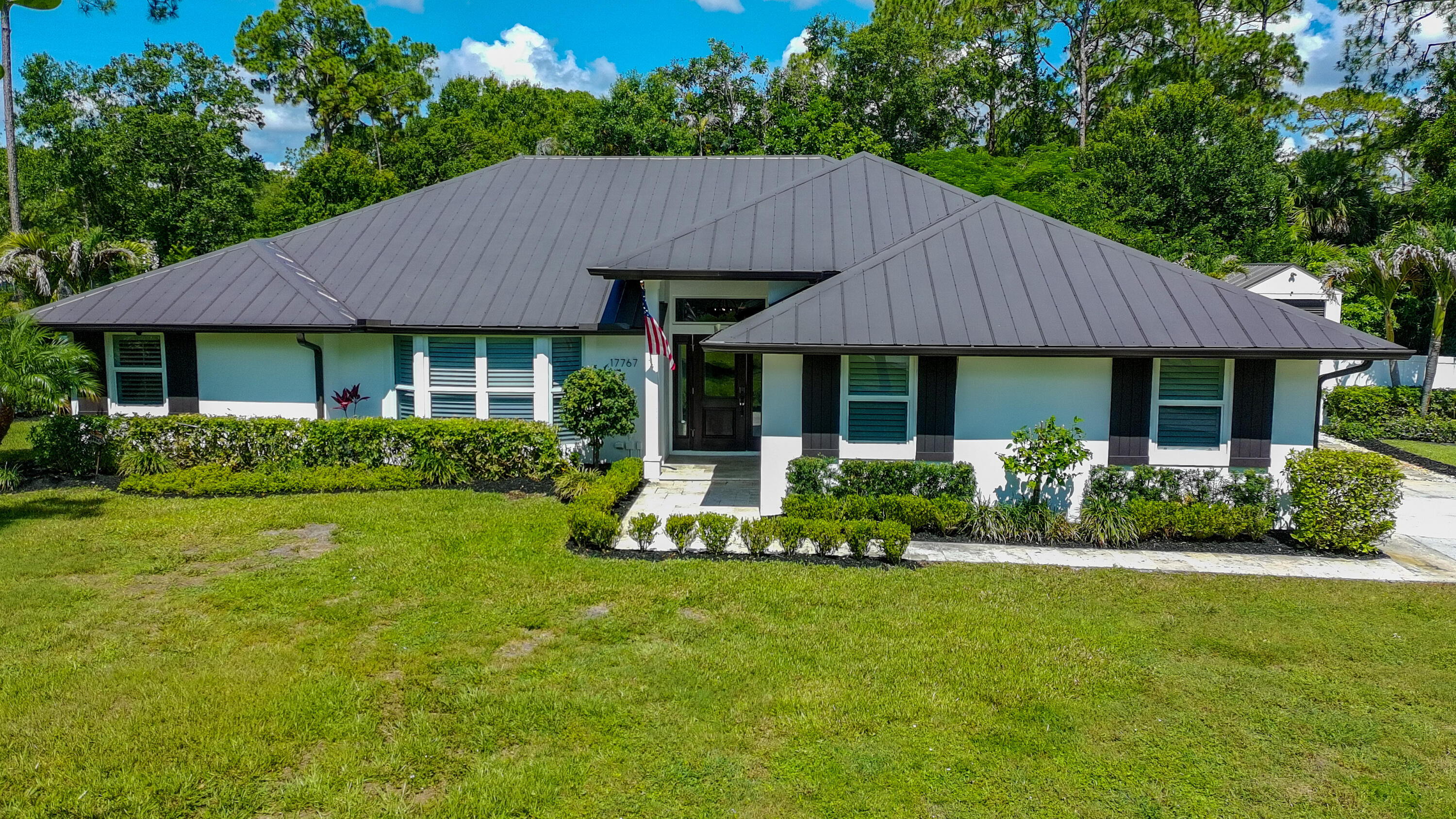 Welcome home to to this exquisite, single-story residence located in Jupiter Farms!  Offering 2,128 square feet of comfortable living, this three-bedroom, two-bathroom home provides ample room for various lifestyle needs, whether you're seeking a personal retreat or flexible space for guests and hobbies. The stunning open-concept floor plan consists of a large family room and dining room with views of the lush, tropical back yard, while the upgraded kitchen is equipped with a new refrigerator, quartz countertops, large center island, and soft close cabinets and drawers.  Relax in your own resort-style yard with lush landscaping, a doll-house-like shed (perfect for storage), a fire pit area, and covered patio, all perfect for entertaining!  The 2-car garage has plenty of space for storage and includes a house generator.  The windows and doors are hurricane impact and roof is metal and freshly painted.  Located on a paved road, close to shopping, excellent schools, a short-drive to the beach, and amazing restaurants, makes this home a must -see!
