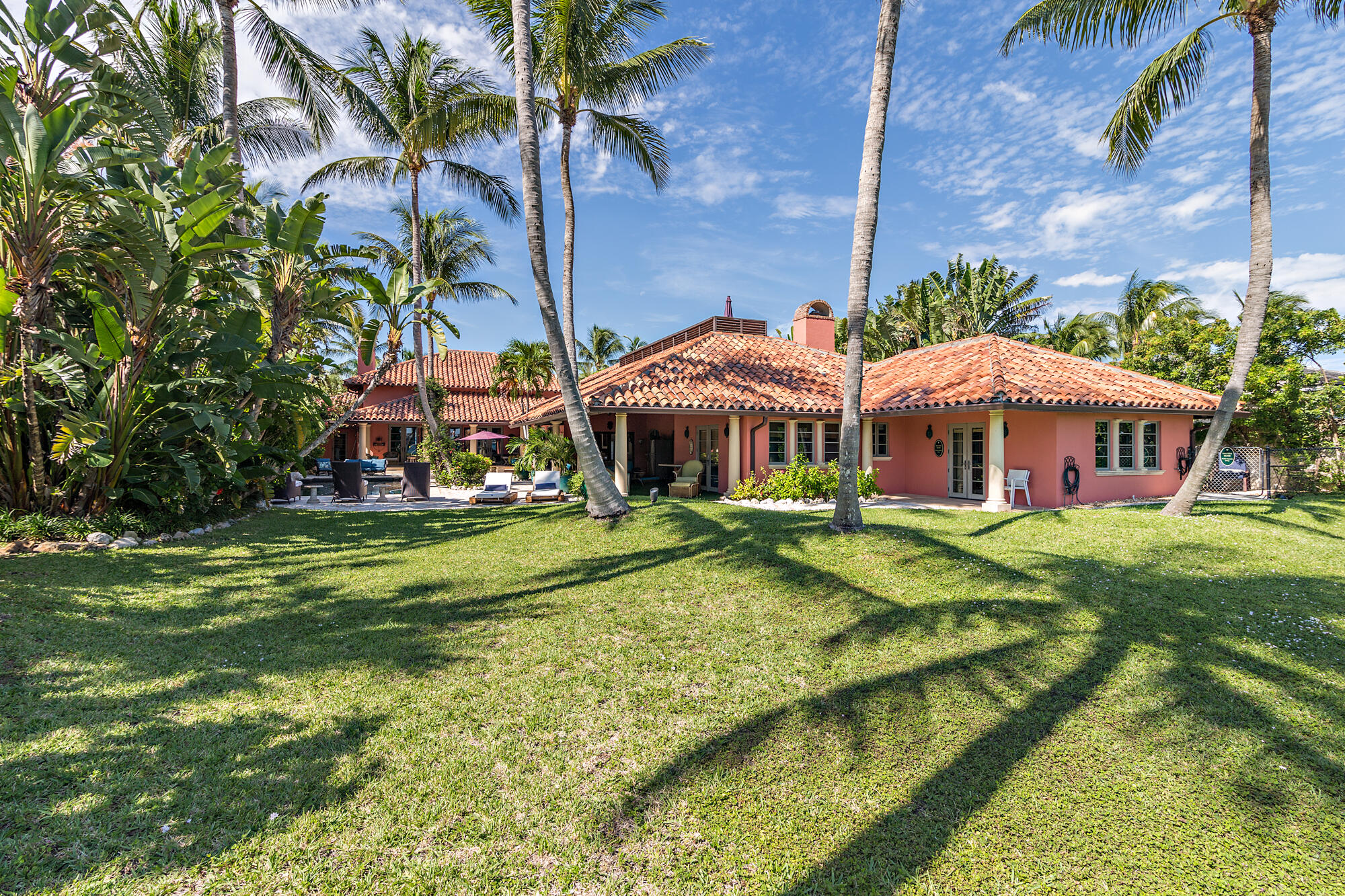 The Flagler House is a tropical waterfront oasis located in West Palm Beach on over an acre. This property encompasses exquisitely manicured grounds with a sprawling 100-ft of frontage on the Intracoastal waterway. The primary residence has 5 bedrooms, 4 full and 3 half bathrooms, a grand family and dining room with fireplace, pub/game room, and outdoor loggias. Two guest cottages (3BR/1BA and 1BR/1BA). Perfect for entertaining with an expansive backyard, pool, 70-ft dock, and nearby Rybovich Marina.