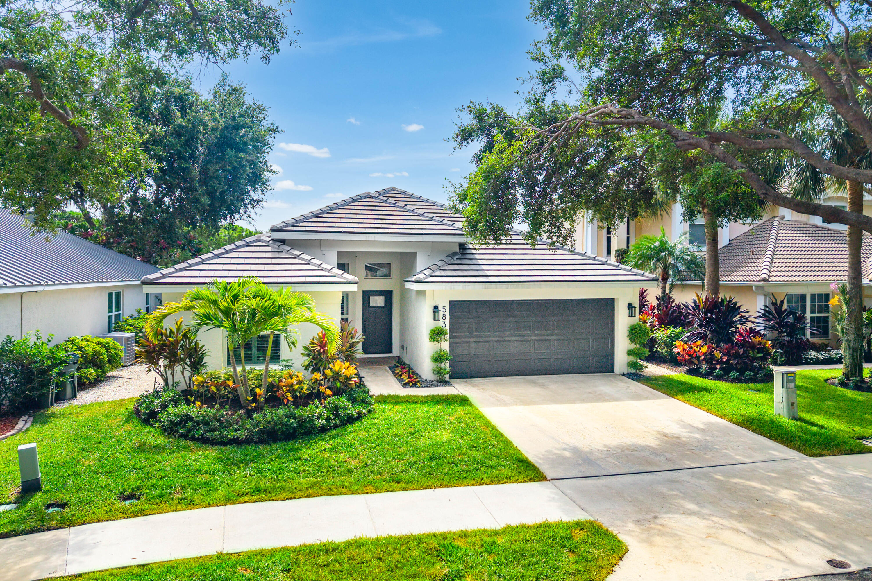 Welcome to 583 Canoe Point, a beautifully updated lakefront residence in the highly sought-after Delray Lakes, an exclusive gated community in East Delray, known for its mature tree-lined streets, serene setting, and rare proximity to downtown.  This 3-bedroom, 2-bath home is truly move-in ready. Enjoy tranquil lake views and stunning east-facing sunrises from your private backyard oasis, complete with a salt chlorination pool featuring a sun shelf/splash deck, electric heater/chiller, and a fully equipped summer kitchen, perfect for effortless outdoor entertaining.  The home has been thoughtfully upgraded throughout, including a renovated kitchen (2021), updated bathrooms, refinished flooring, and major system improvements: new roof (2023), exterior paint (2023), and A/C (2022).  Impact windows and sliders provide peace of mind and energy efficiency.  Additional highlights include a fully fenced yard, quiet and private setting, and a peaceful lakefront lifestyle enhanced by cooling breezes off the water.  Delray Lakes offers a unique blend of security, charm, and location, just minutes from Atlantic Avenue, beaches, and top dining—making this home an exceptional value in one of East Delray's most desirable gated communities.