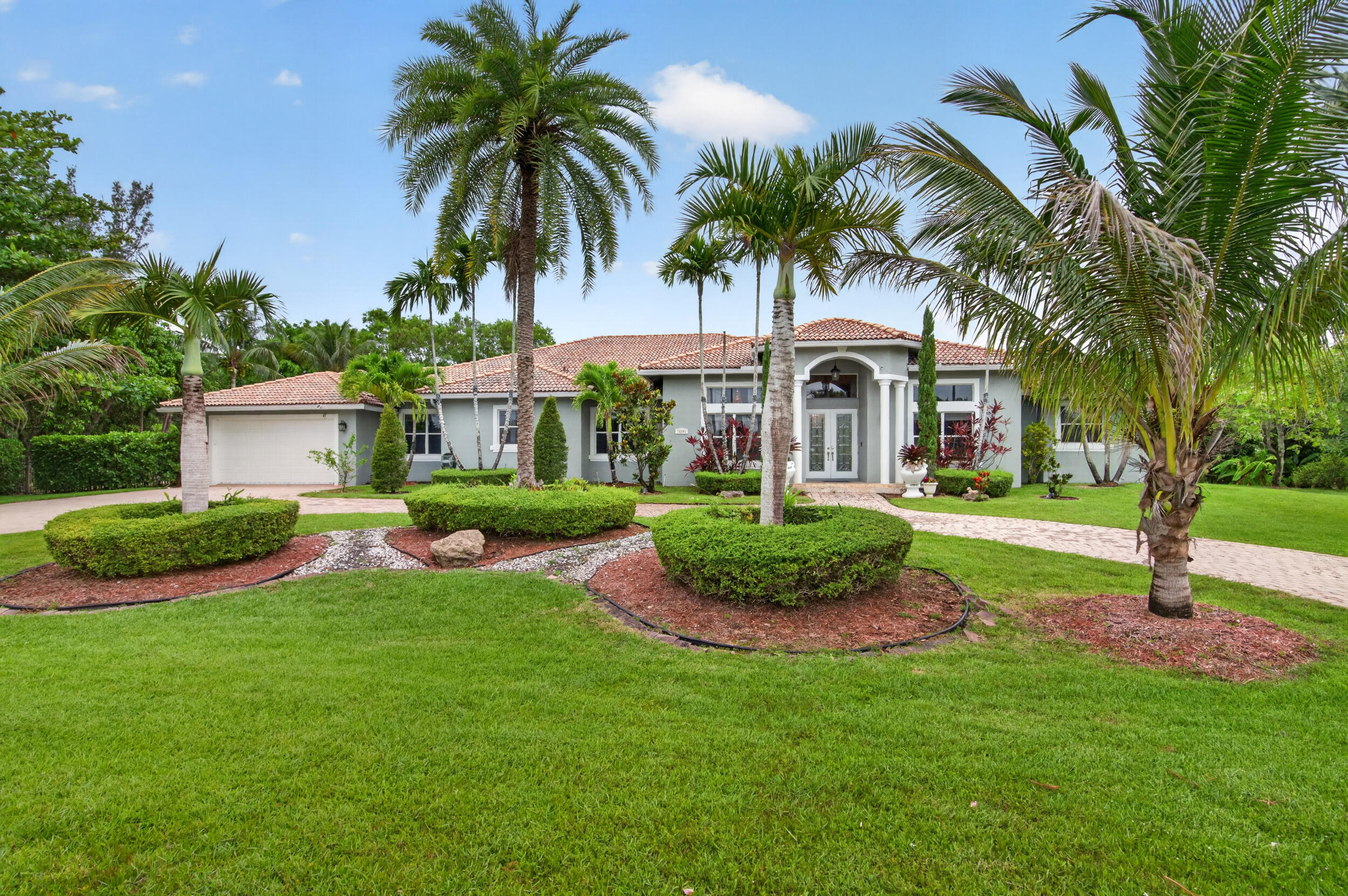 Experience the best of Southwest Ranches living in this private one-story retreat set on a lush builder's acre with no HOA. Currently a thriving Airbnb, this 4-bedroom, 4.5-bath home blends comfort and resort-style outdoor living with soaring ceilings, updated finishes, porcelain and tile floors, and a spacious split-bedroom layout. Step outside to a tropical backyard oasis featuring canal views, fruit trees, a dog run, an 8-foot waterfall pool, jacuzzi, and a massive covered patio with outdoor kitchen perfect for entertaining. Complete with a 2-car A/C garage, tankless water heater, 2018 A/C, and circular driveway for 8-10 cars, this property is perfect as a private escape, income-producing investment, or future custom estate.