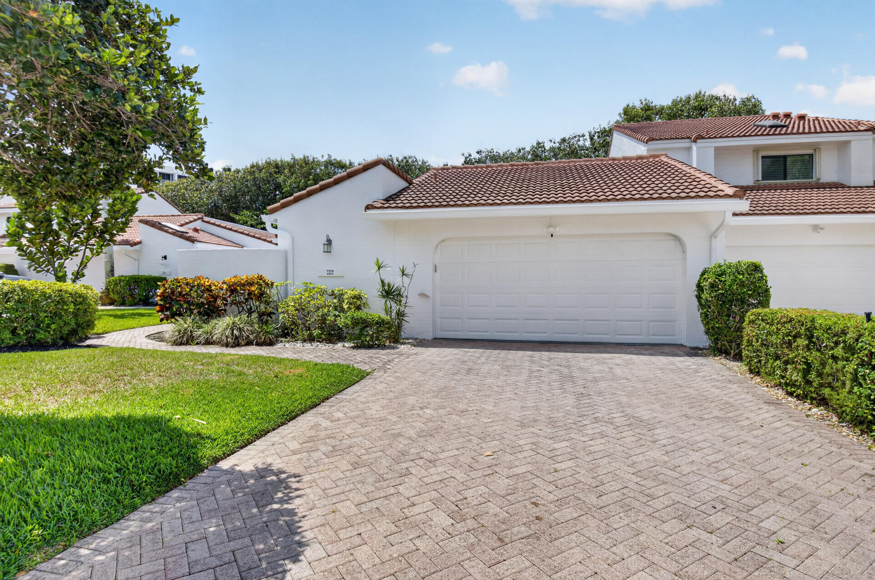 Welcome to 7374 Woodmont Court, a beautifully renovated corner residence in Woodcrest at Boca West Country Club. This 3-bedroom, 2-bath home offers nearly 2,000 square feet of living space with vaulted ceilings, a spacious open layout, new porcelain floors throughout, a stunning new kitchen, and beautifully updated bathrooms. Enjoy indoor-outdoor South Florida living with a new patio, updated pool, and private backyard setting. Additional highlights include a 2-car garage and the privacy of a desirable corner location. Located in one of Boca Raton's premier private country club communities, Boca West offers world-class golf, racquet sports, dining, fitness, social programming, and resort-style amenities. Ideally situated near shopping, dining, beaches, and downtown Boca Raton.