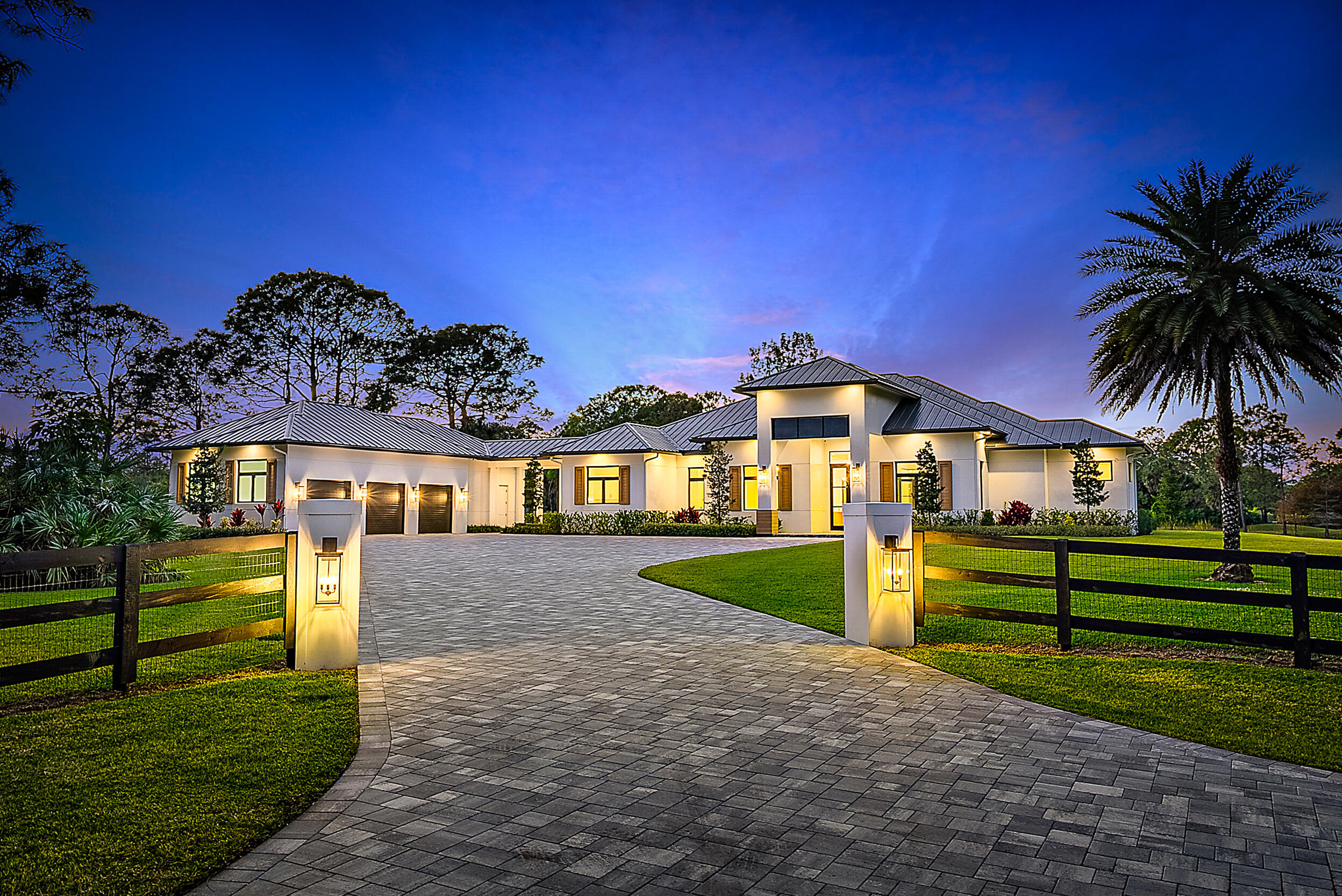 Positioned on 6.51 acres within a private estate community known for expansive homesites and custom residences, this newly constructed home offers a rare balance of privacy, scale, and flexibility. The acreage allows for a variety of uses—whether as a private retreat complemented by a four-bay garage with lift-height ceilings, or with the option to expand into an equestrian setup or add separate guest quarters. The living space is open and modern, with high ceilings and warm, luxury farmhouse finishes. The home is well-equipped with a full-house reverse osmosis (RO) water system, propane tank, and generator hookup. Indoor living extends to a covered patio with speakers and a summer kitchen, alongside a heated saltwater pool and spa. All bedrooms are ensuite, with a dedicated office/den and a spacious media or recreation room. Located near the community's 30-acre equestrian park, miles of bridle trails, and nearby stables—yet just minutes to shopping, dining, golf, and the beach—the setting offers a balance of privacy and convenience.